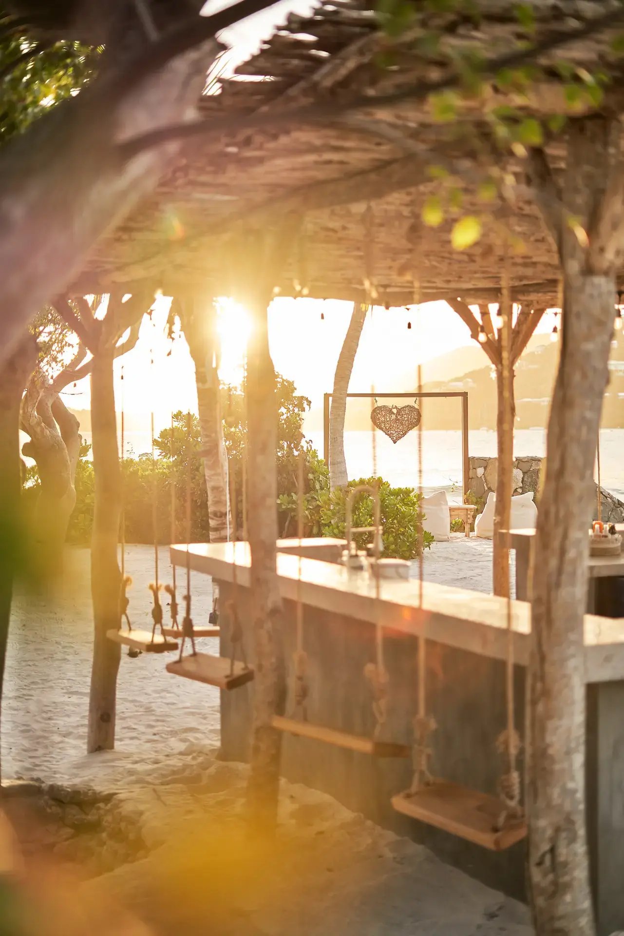 Outdoor bar with swing seats at sunset at The Aerial, BVI.