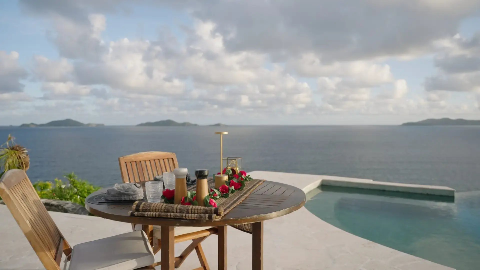 Table set beside the infinity pool overlooking the ocean at The Aerial BVI