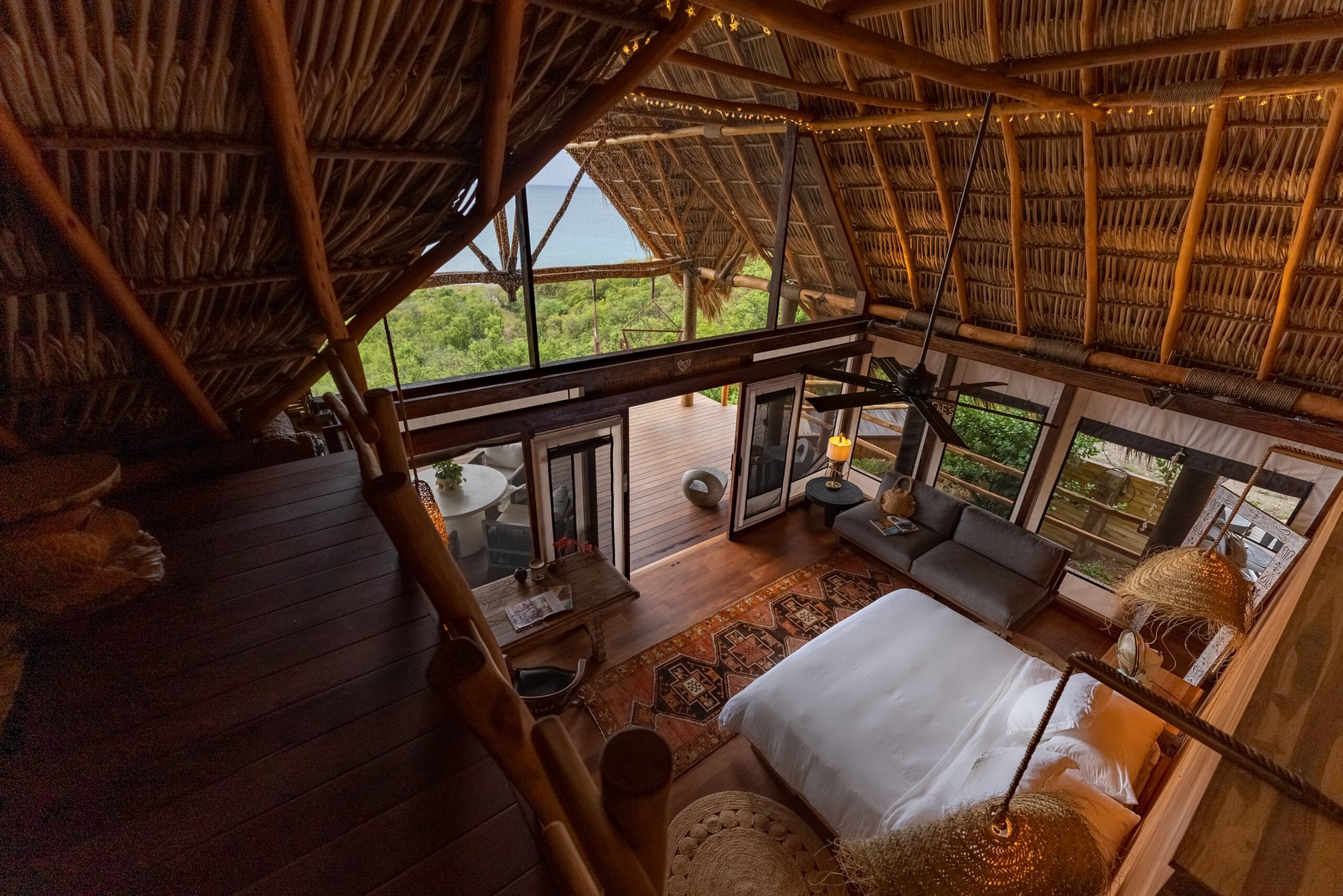 Overhead view of a thatched cabin's living and bedroom area.