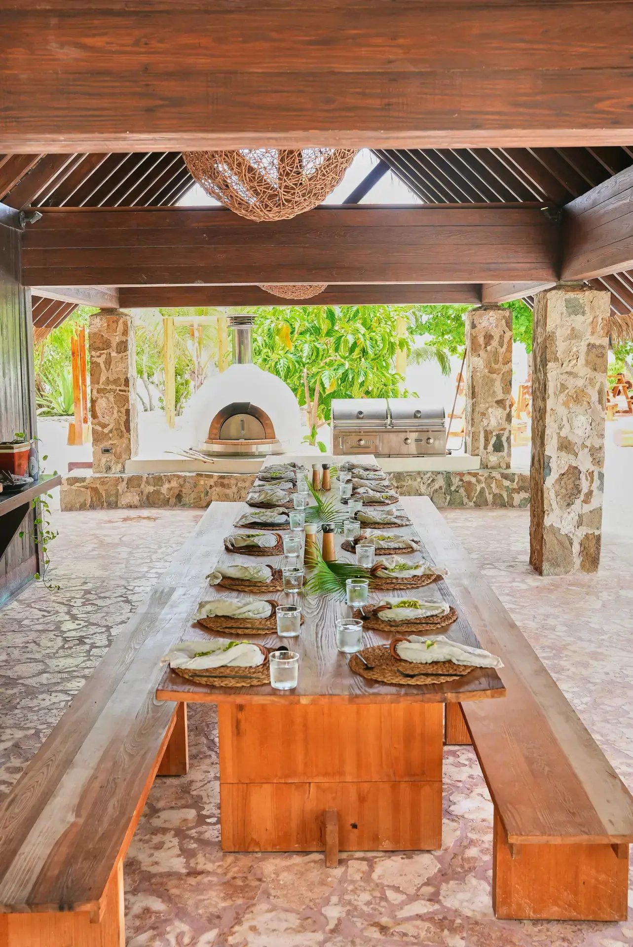 Dining table set beside a wood-fired oven at Peace Pavilion, The Aerial BVI
