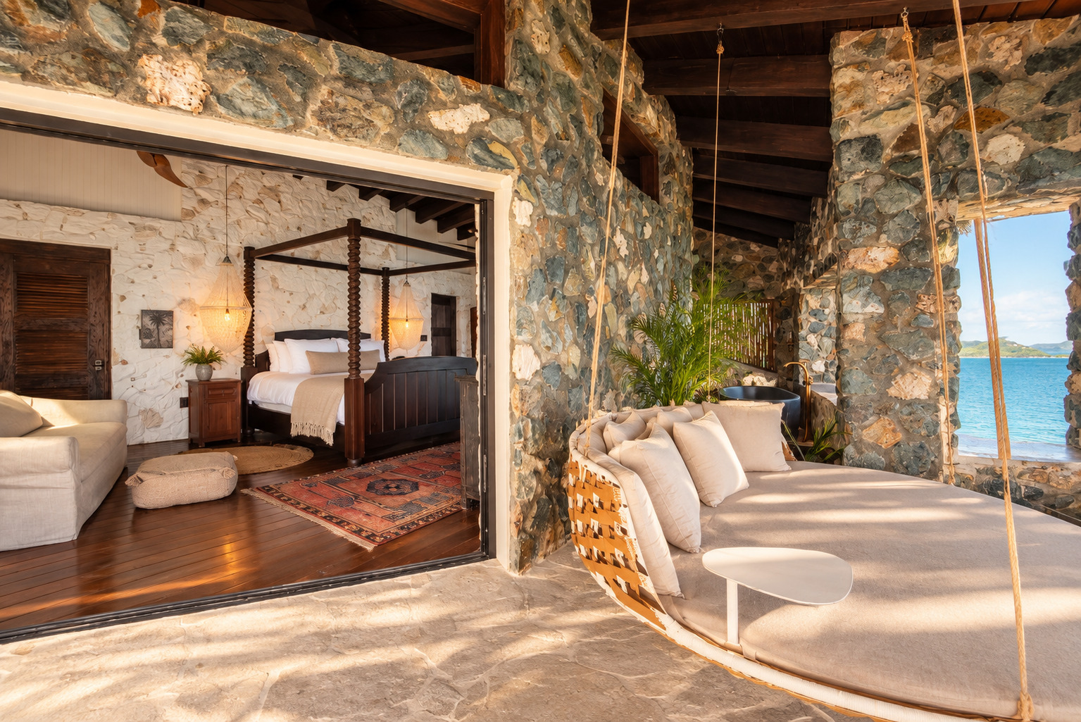Bedroom opening to a stone-walled outdoor lounge at The Aerial, BVI