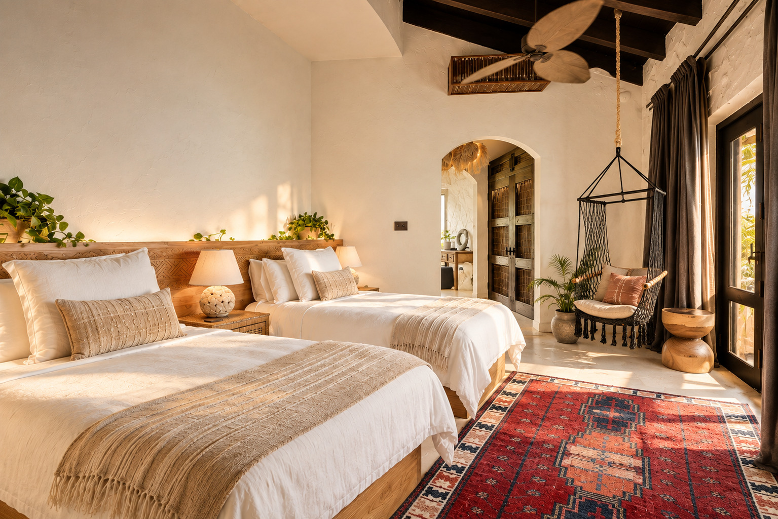 Twin beds with hanging chair and stone archway at The Aerial, BVI