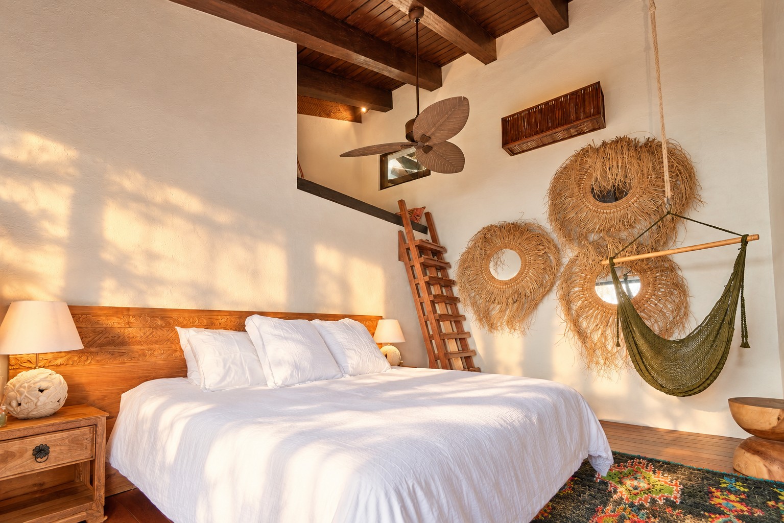 Bedroom with woven wall hangings, ladder, and hanging hammock chair.