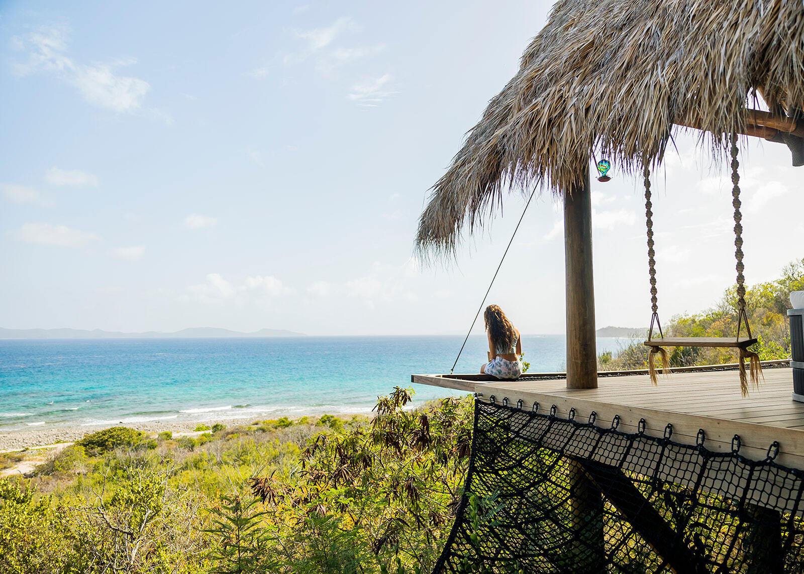 Hanging swings under a thatched pavilion overlooking the ocean at The Aerial, BVI