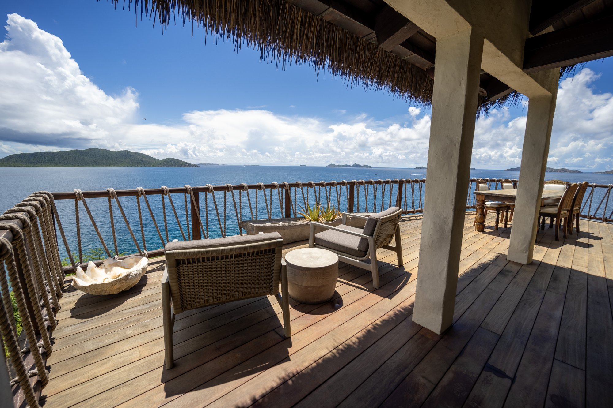 Ocean-view deck with lounge seating and dining area.