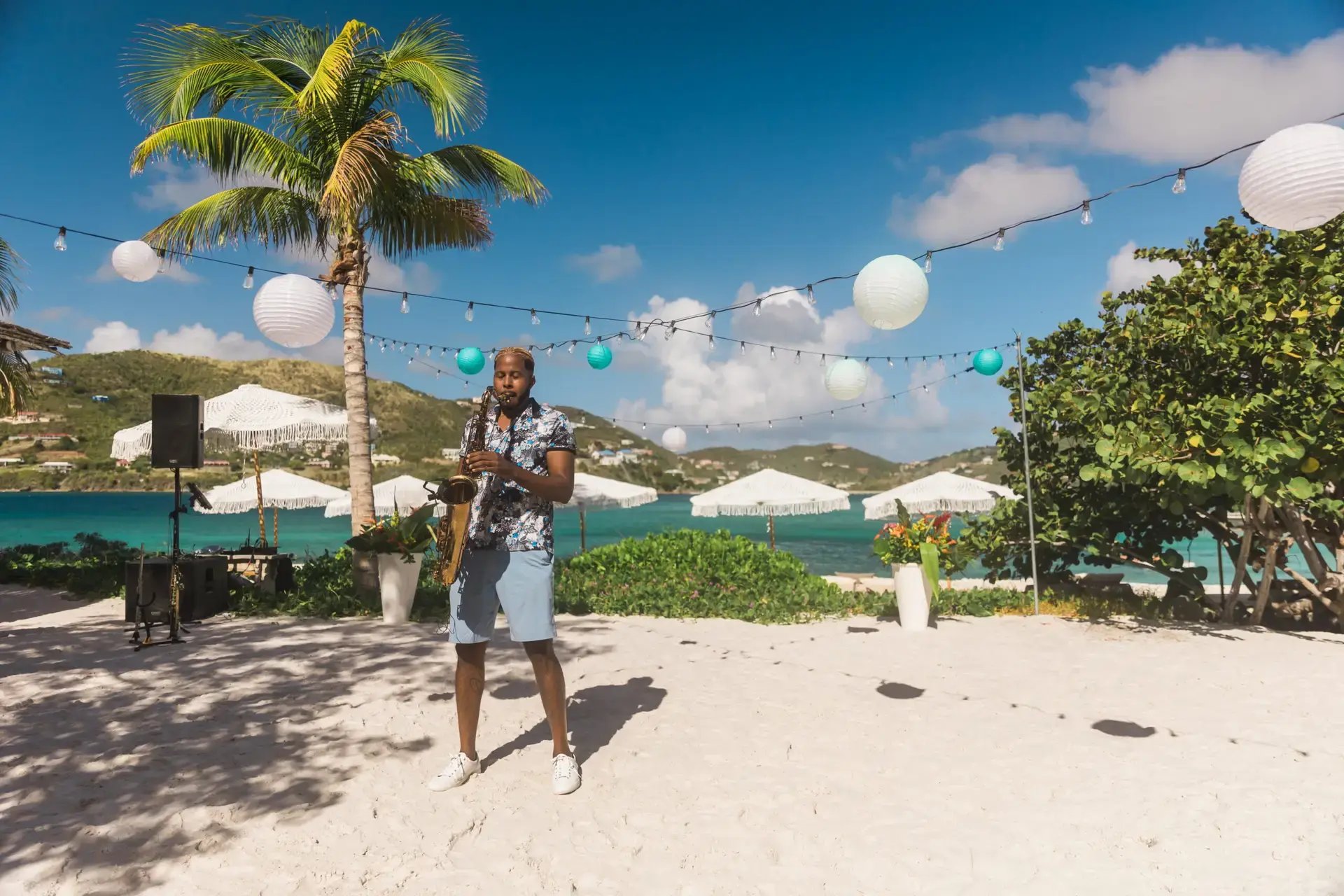 Beach celebration setup with string lights and a live musician at The Aerial, BVI