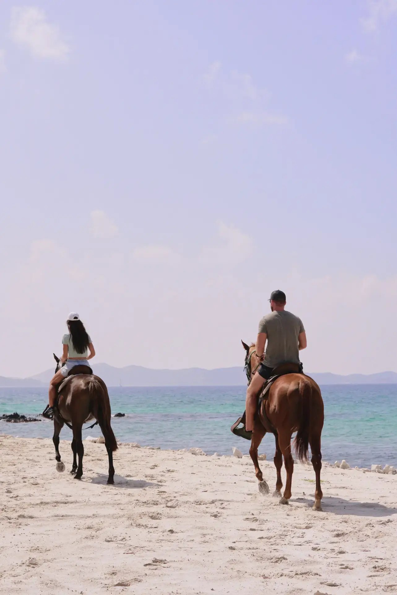 Two guests horseback riding along the beach at The Aerial BVI