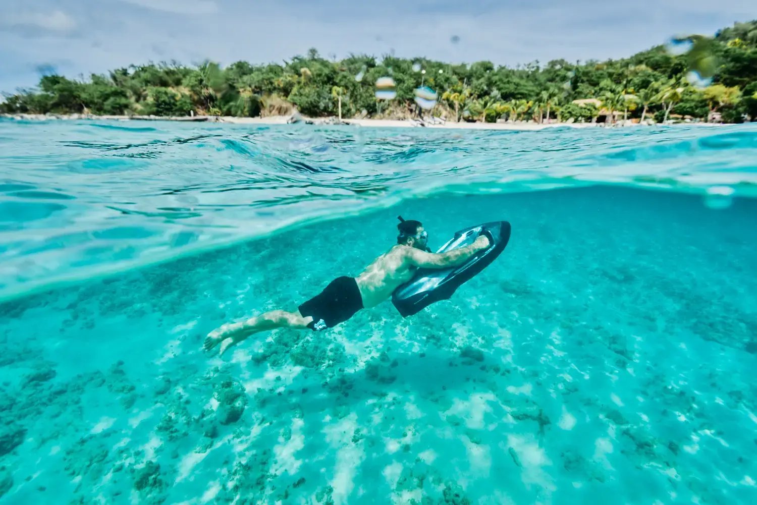 Snorkeler swimming over a reef in the turquoise waters at The Aerial, BVI