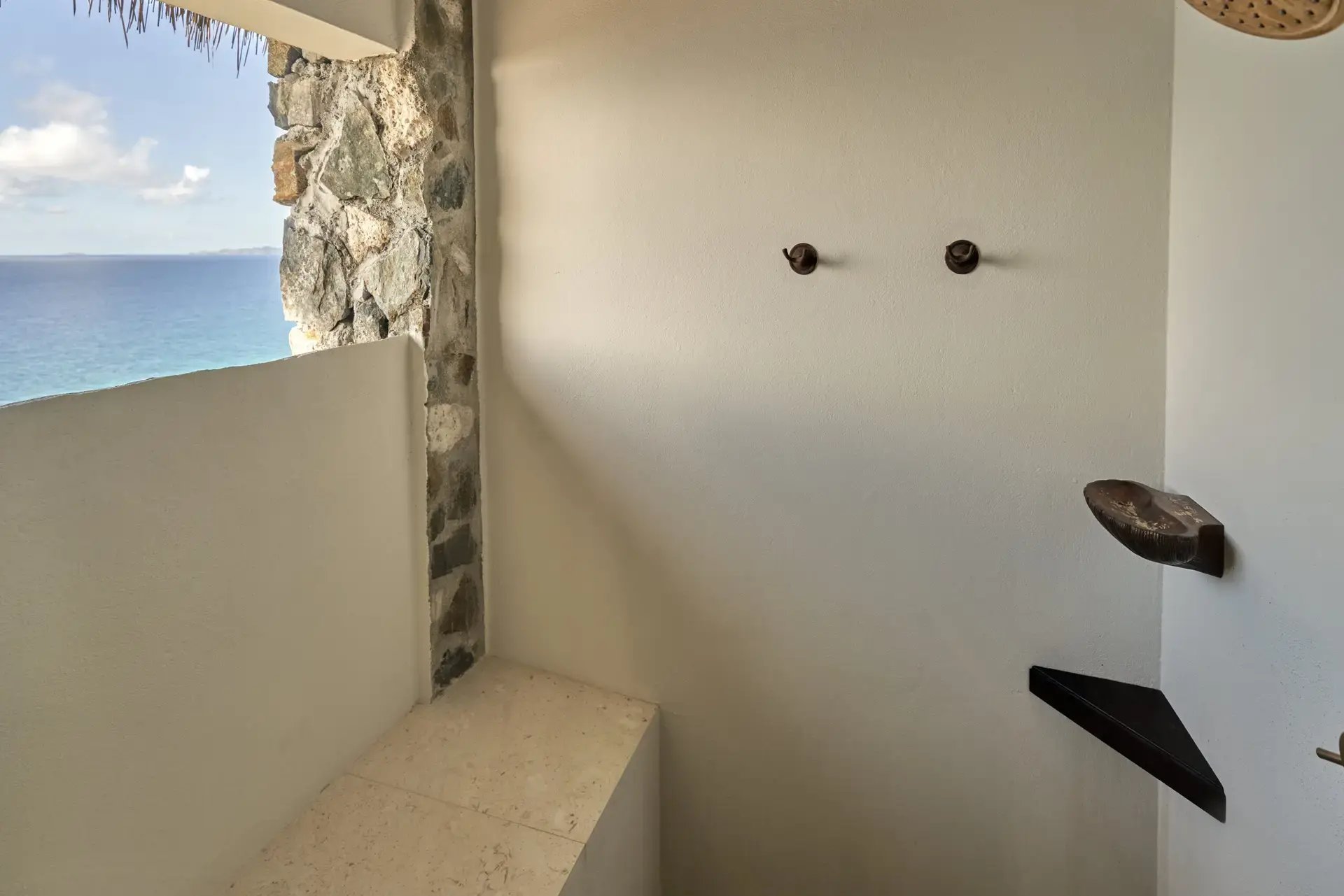 Corner outdoor shower with ocean-view opening.