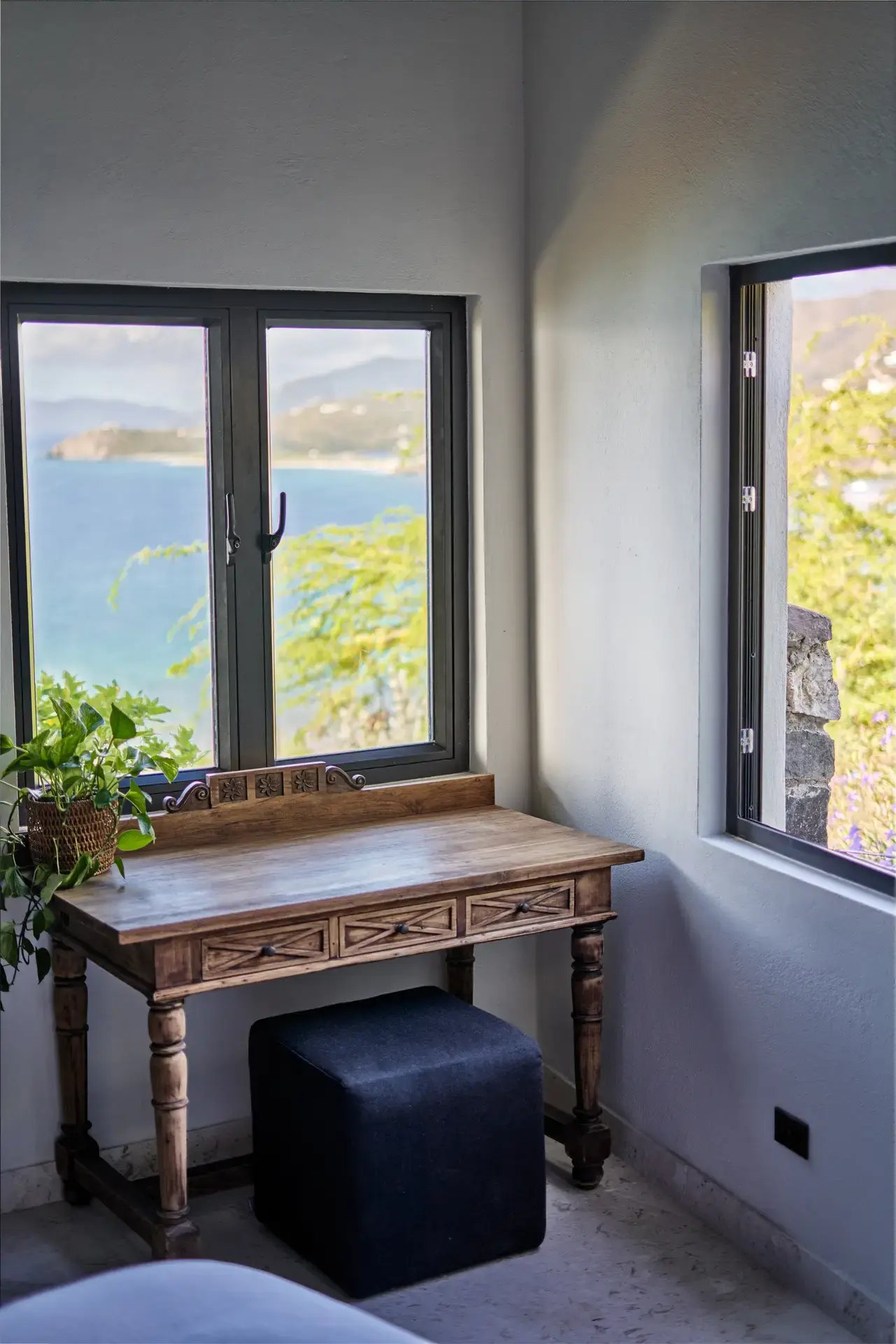 Wooden desk by a window with ocean view.