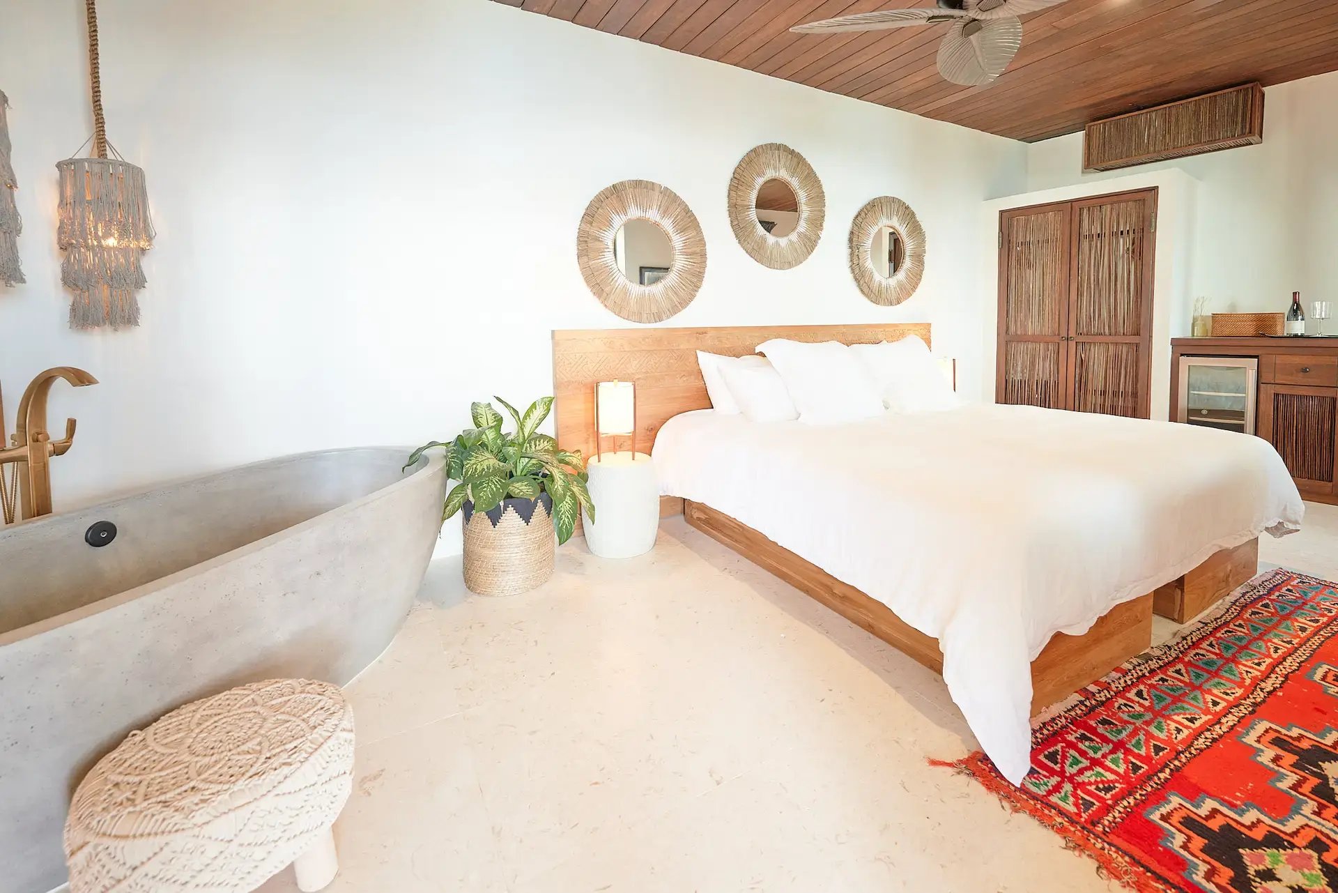 King bed and soaking tub with sunburst mirror wall at The Aerial, BVI