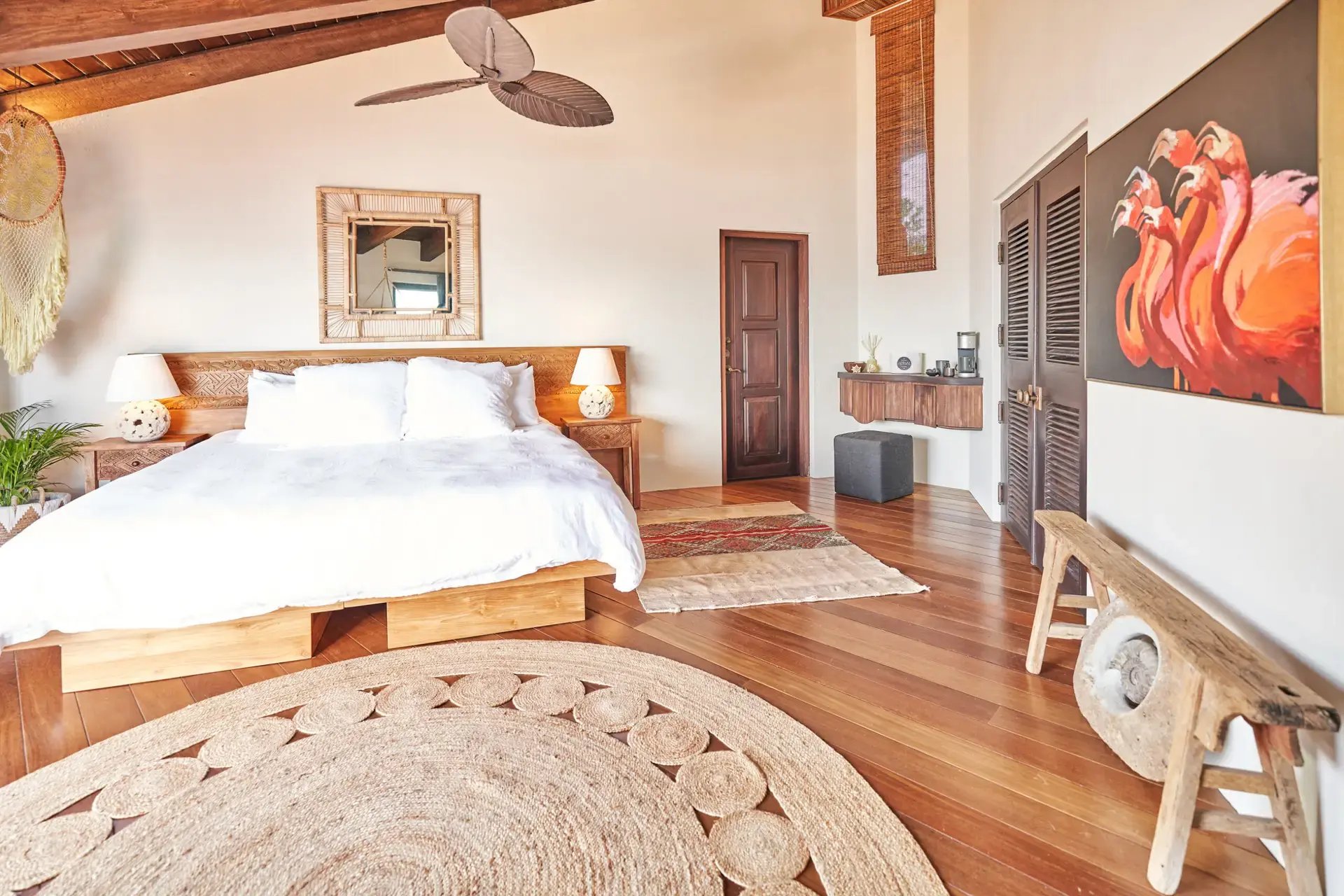 Bedroom with wood-beam ceiling and flamingo painting.