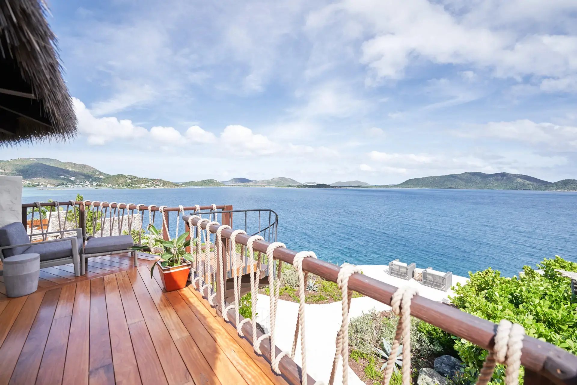 Oceanview deck with rope railing and lounge seating.