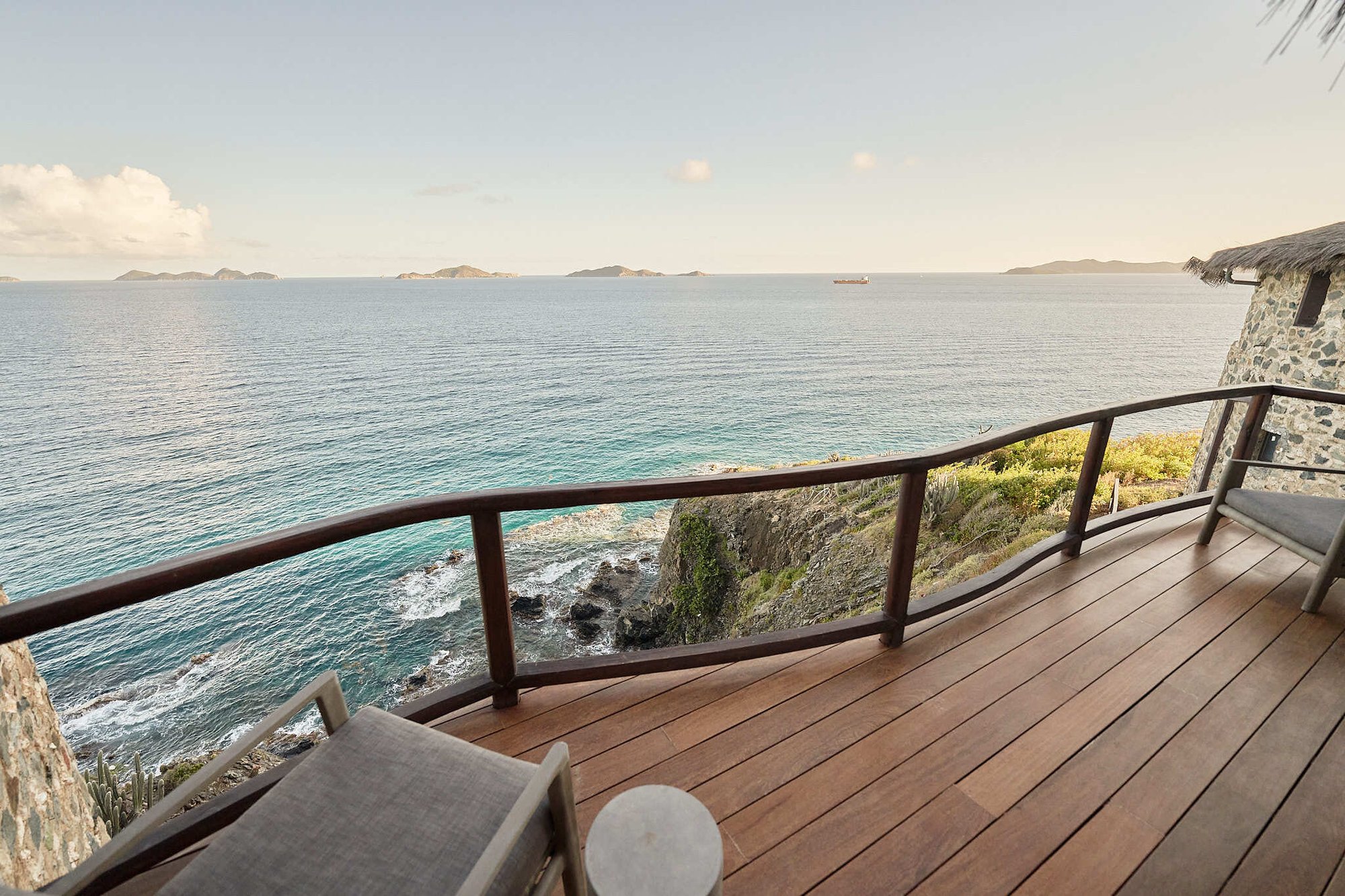 Cliffside deck overlooking the ocean with lounge seating.