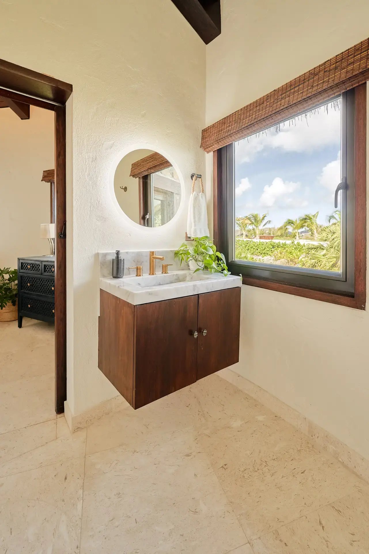 Bathroom vanity with round mirror and garden view at The Aerial, BVI