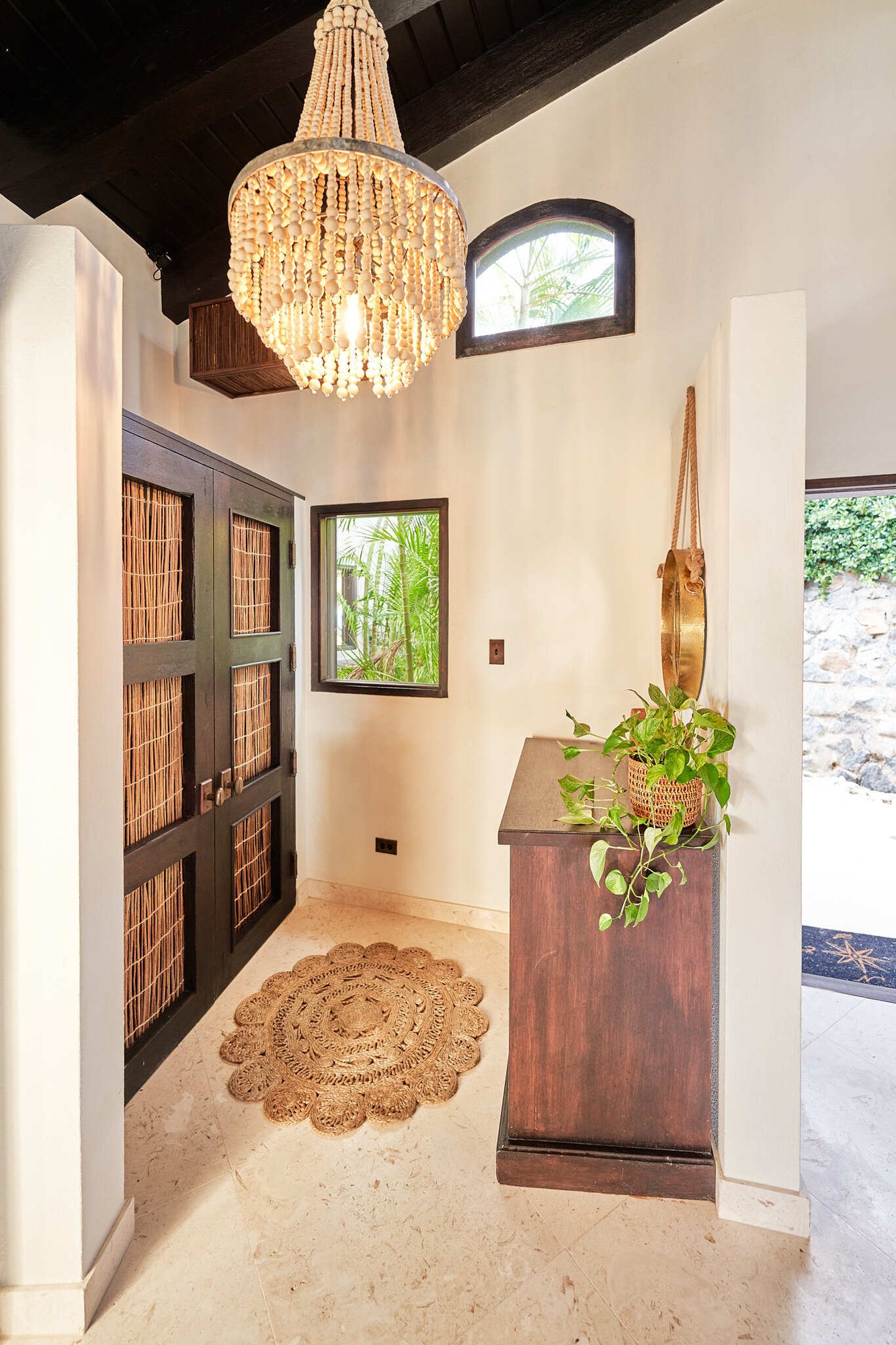 Entryway with beaded chandelier and wood cabinet doors