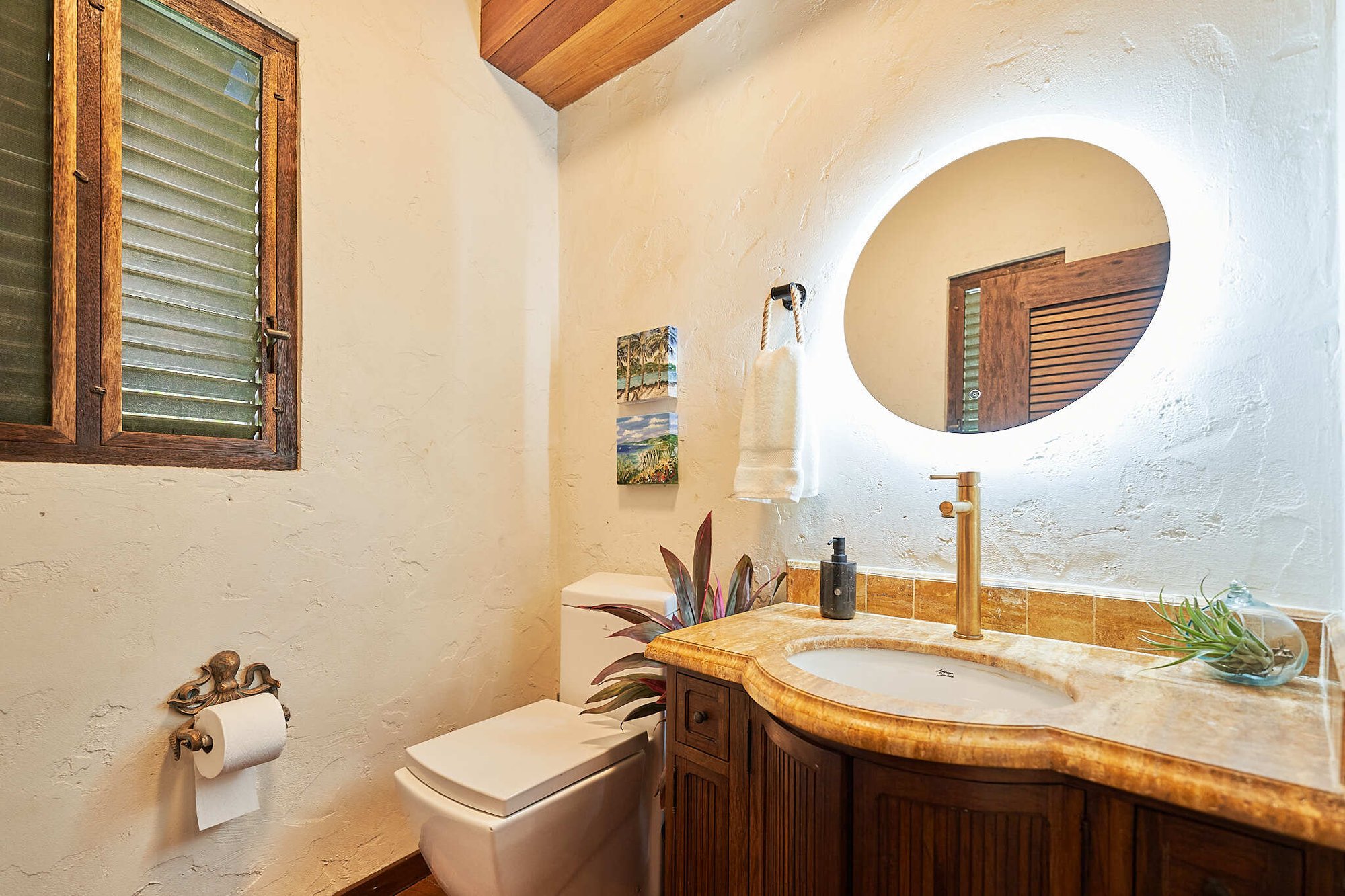 Bathroom with round backlit mirror and stone vanity