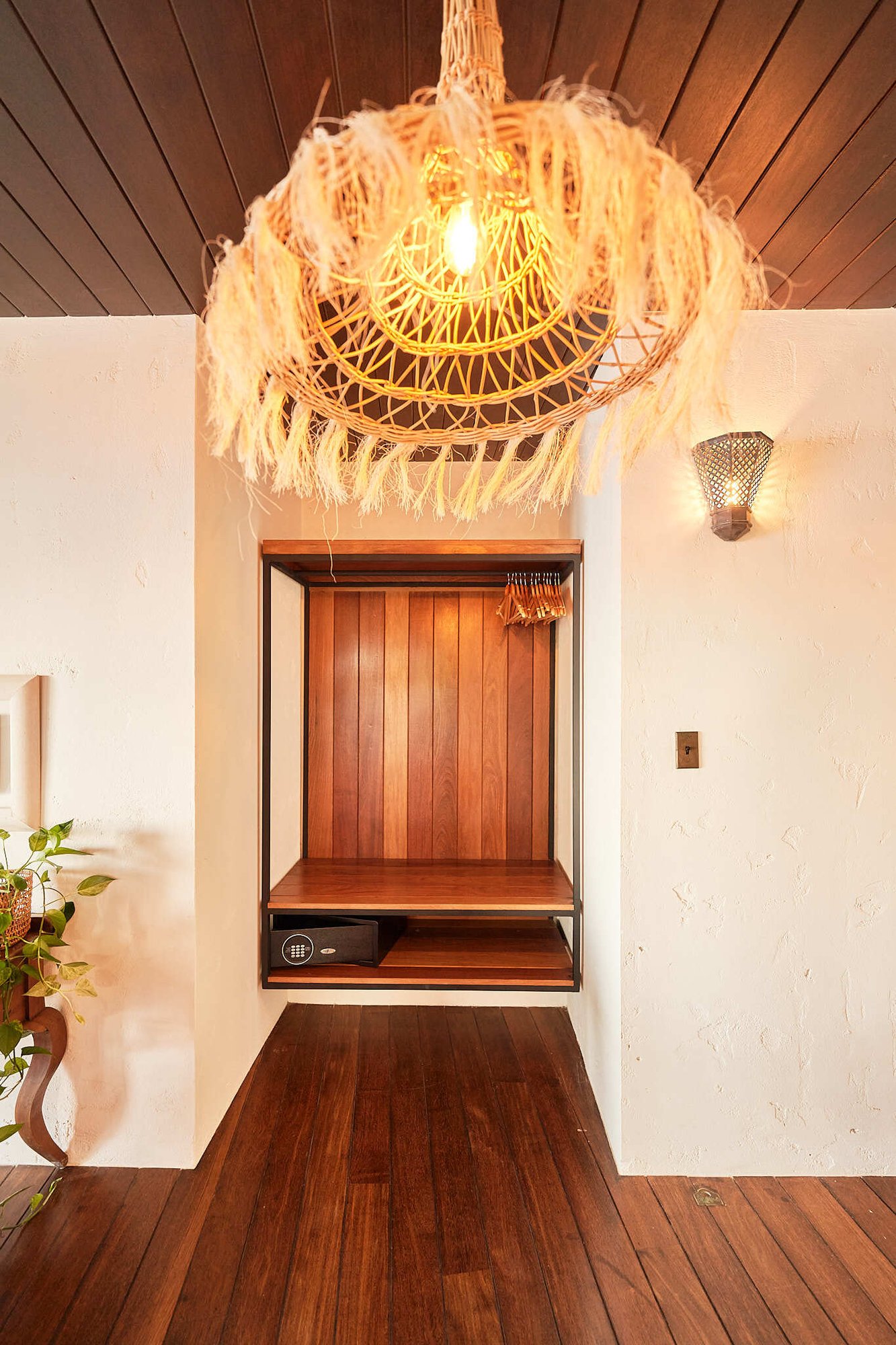 Entryway nook with built-in closet and woven pendant light.