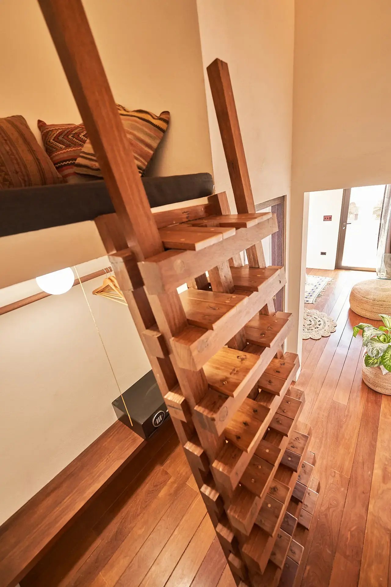 Wooden ladder leading to a loft nook above the room.