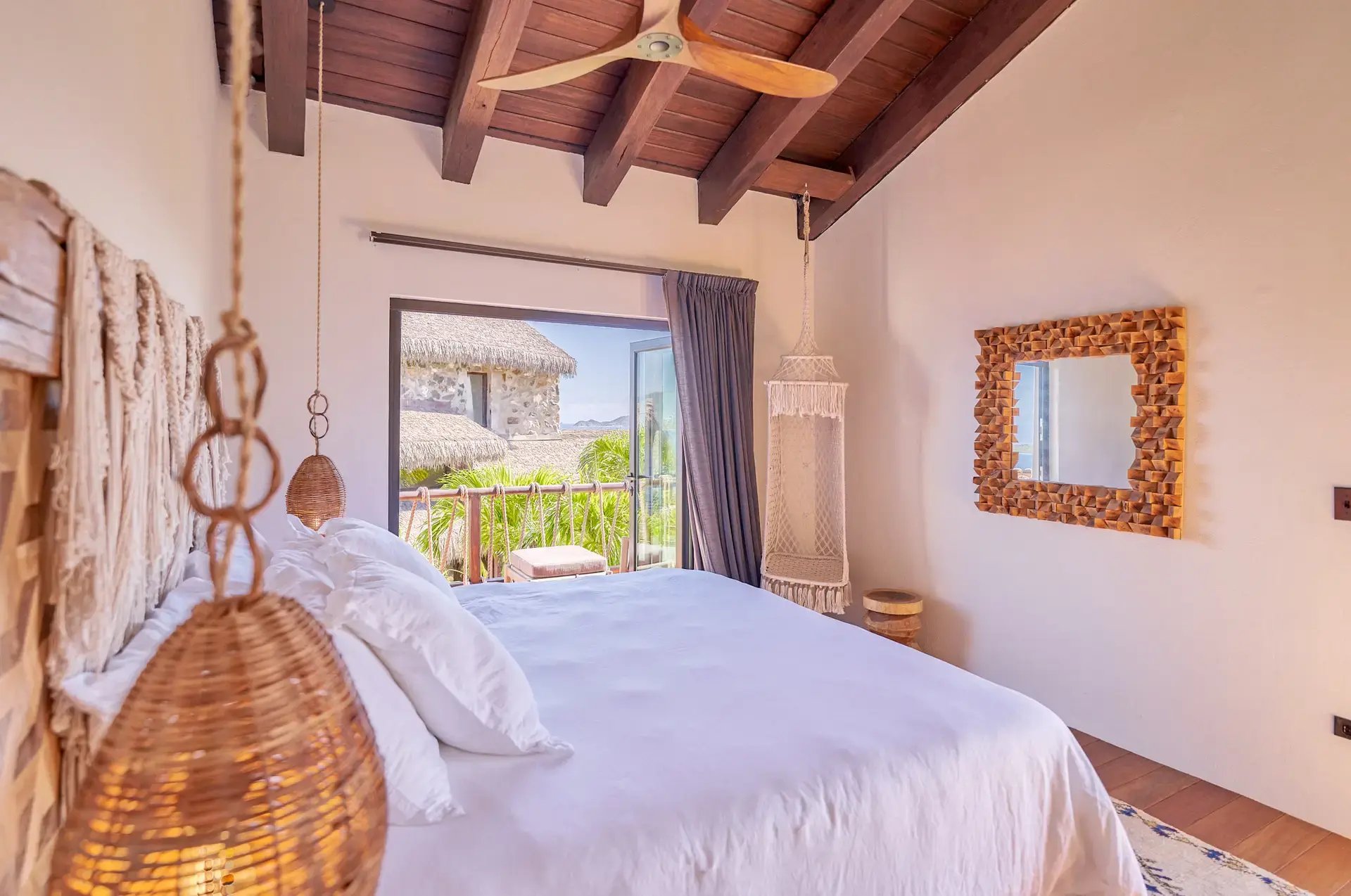 Bedroom with woven pendant lights and wood-framed mirror.