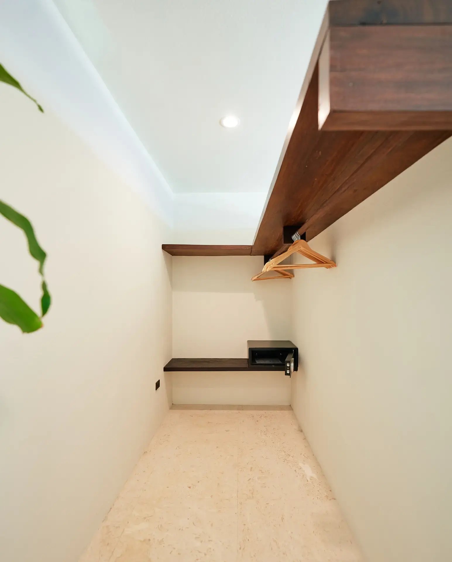 Closet nook with hanging rod and in-room safe.