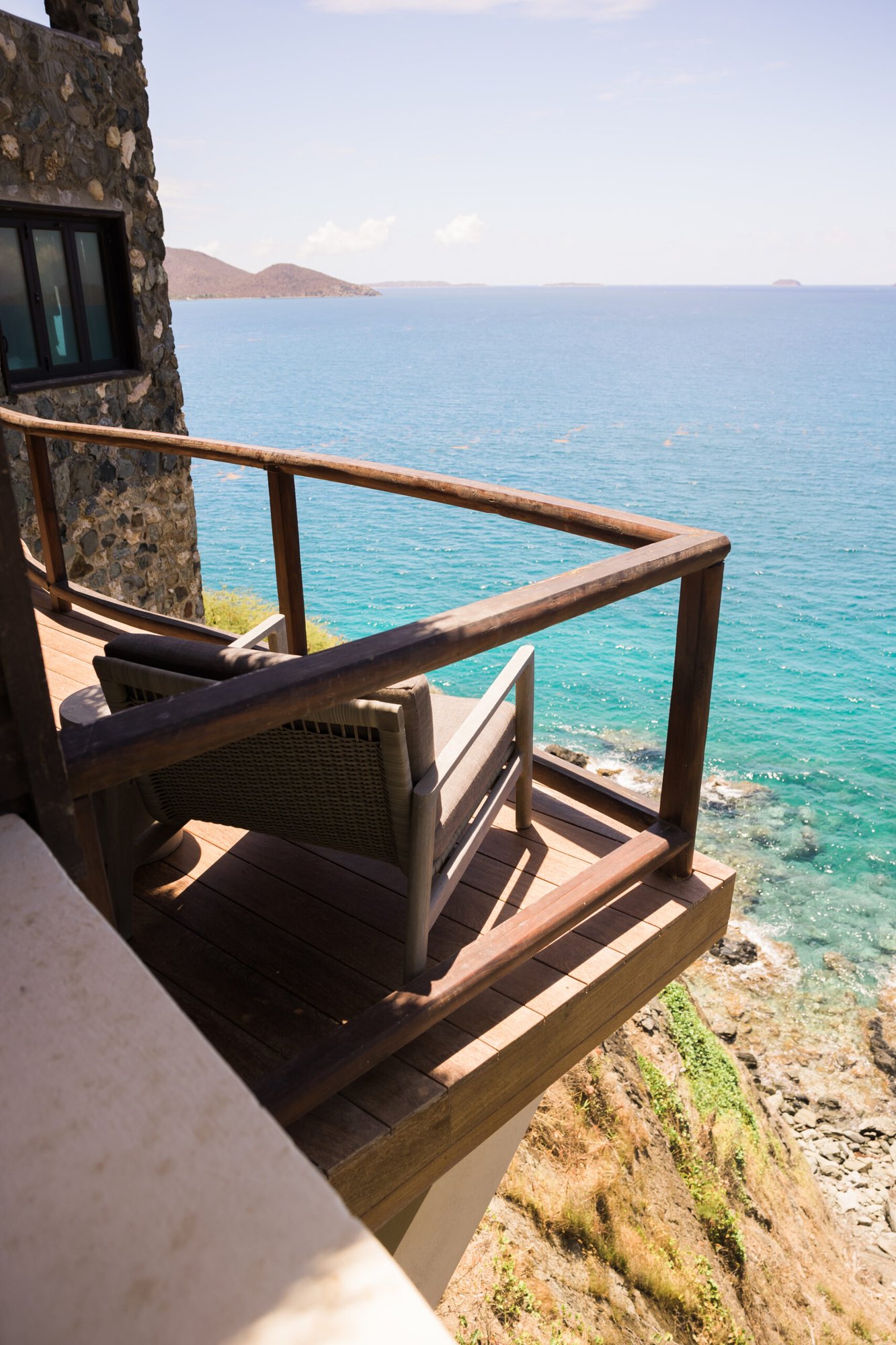 Rocky oceanfront balcony with a single lounge chair.