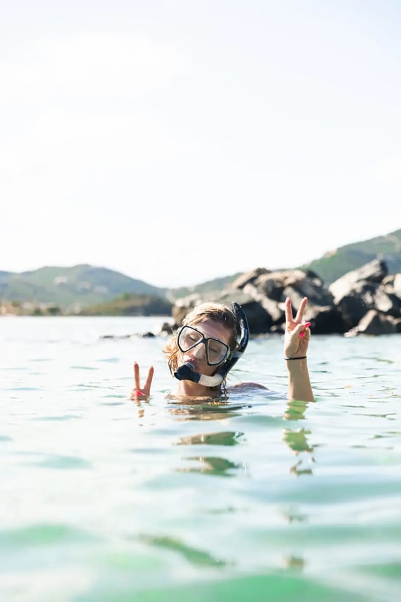 Guest snorkeling and giving a peace sign in the water at The Aerial, BVI