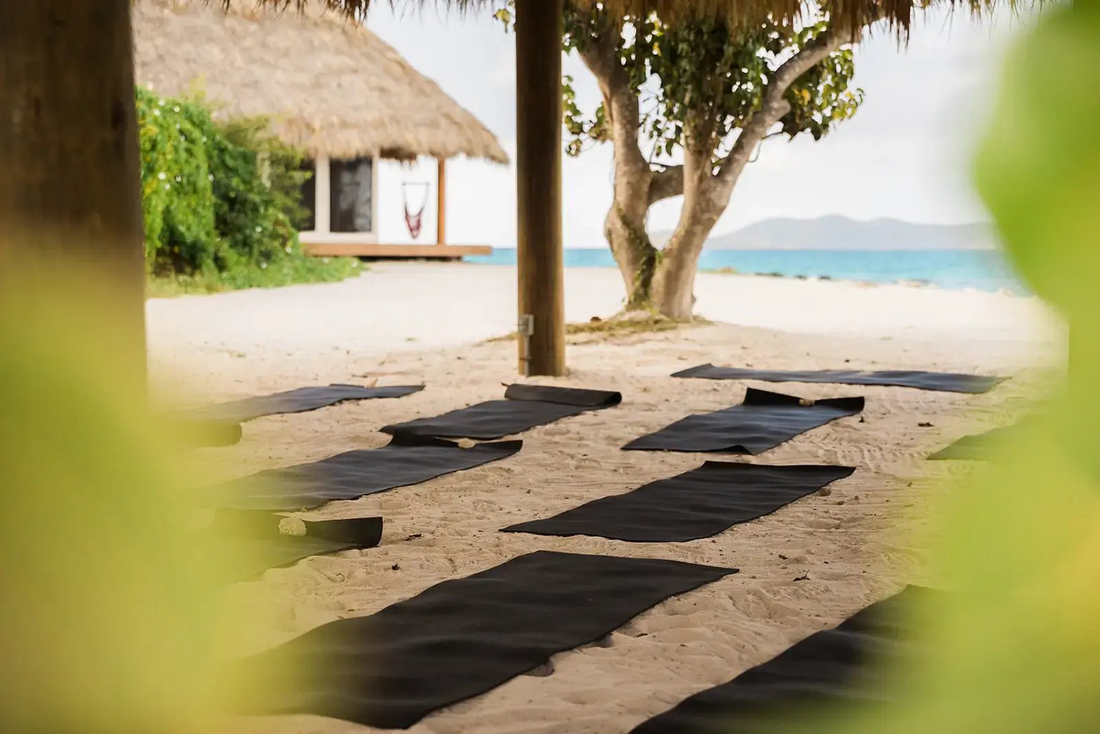 Yoga mats set up on the beach for a group session at The Aerial, BVI