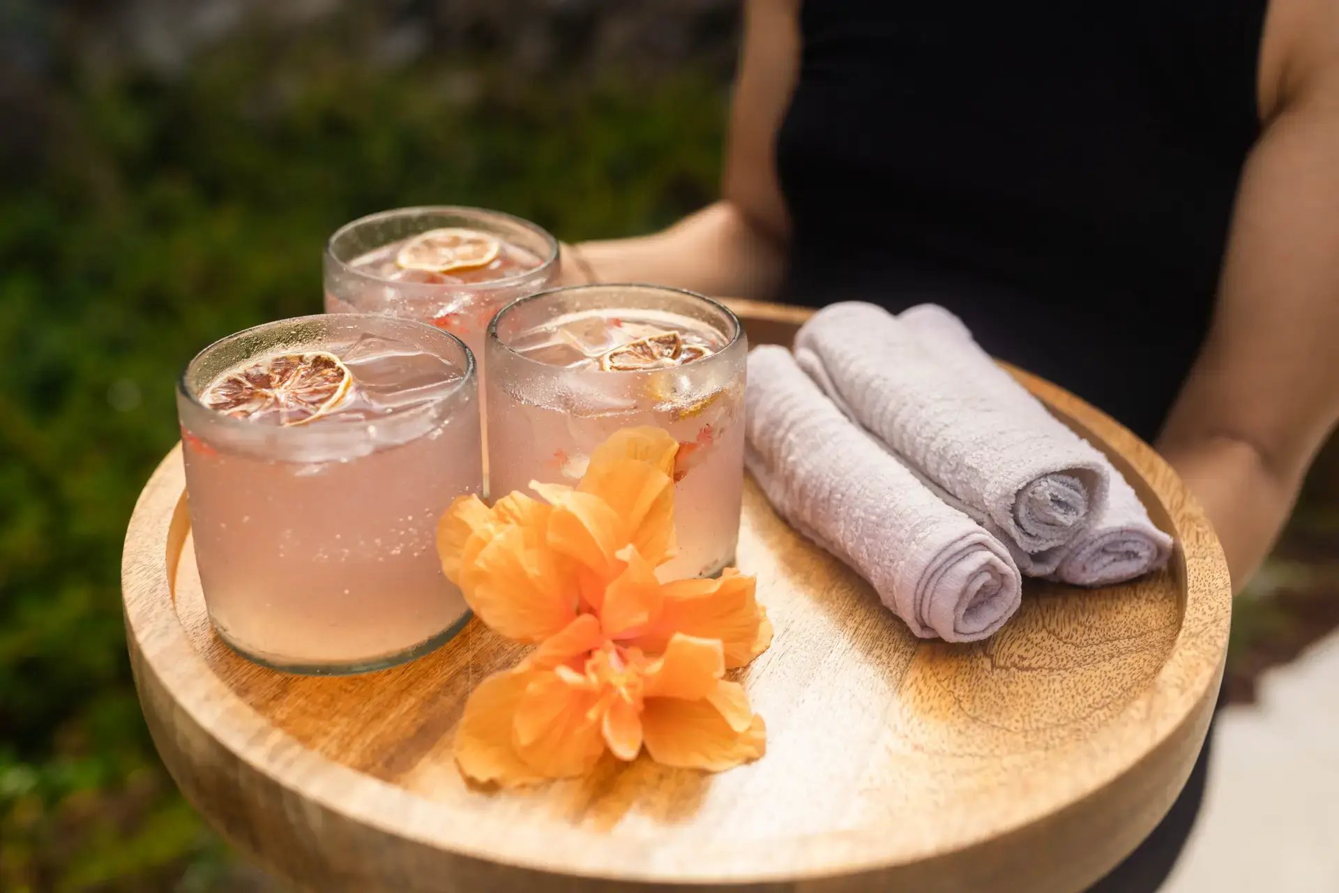 Drinks and a flower arranged on a serving tray with rolled towels at The Aerial BVI