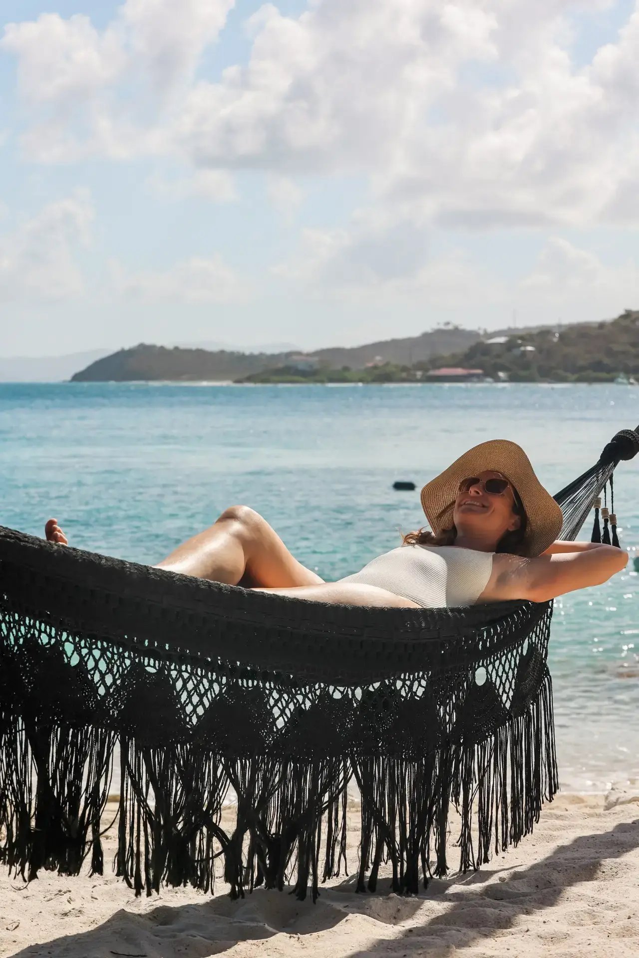 Guest relaxing in a hammock on the beach at The Aerial, BVI