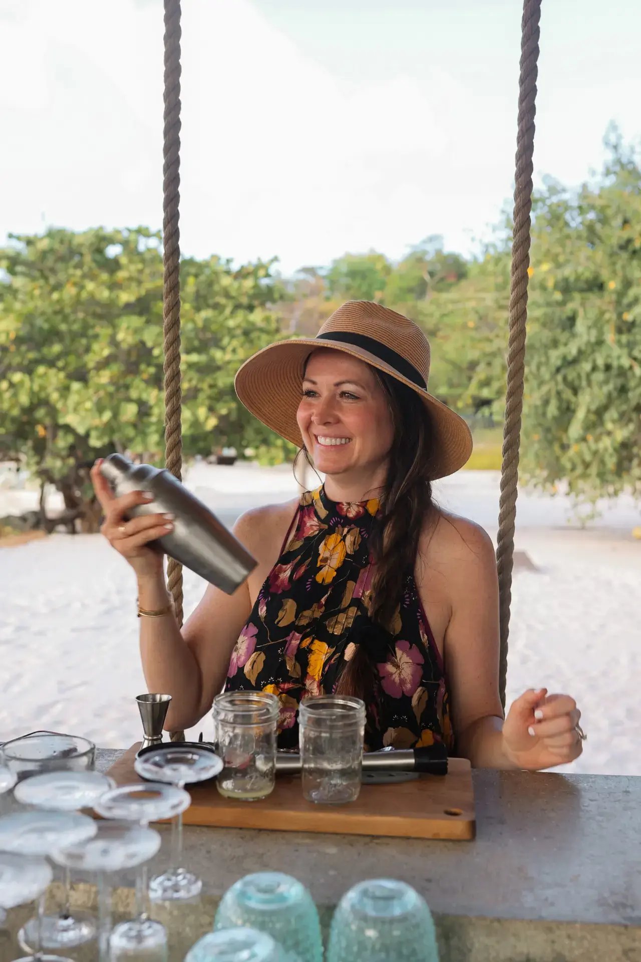 Guest enjoying drinks on a swing seat at the beach bar at The Aerial, BVI.