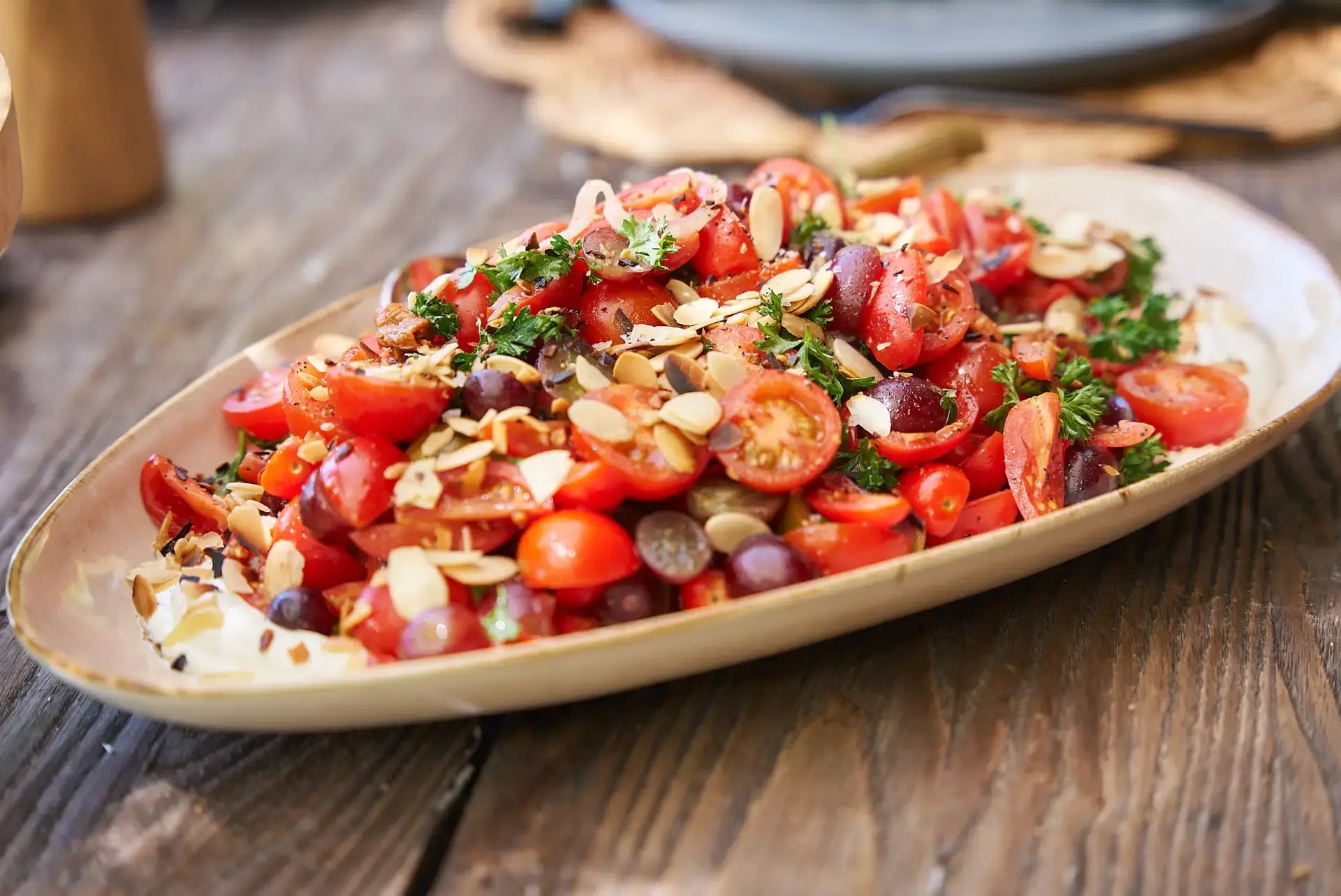 Tomato and almond salad on a wooden table at The Aerial BVI