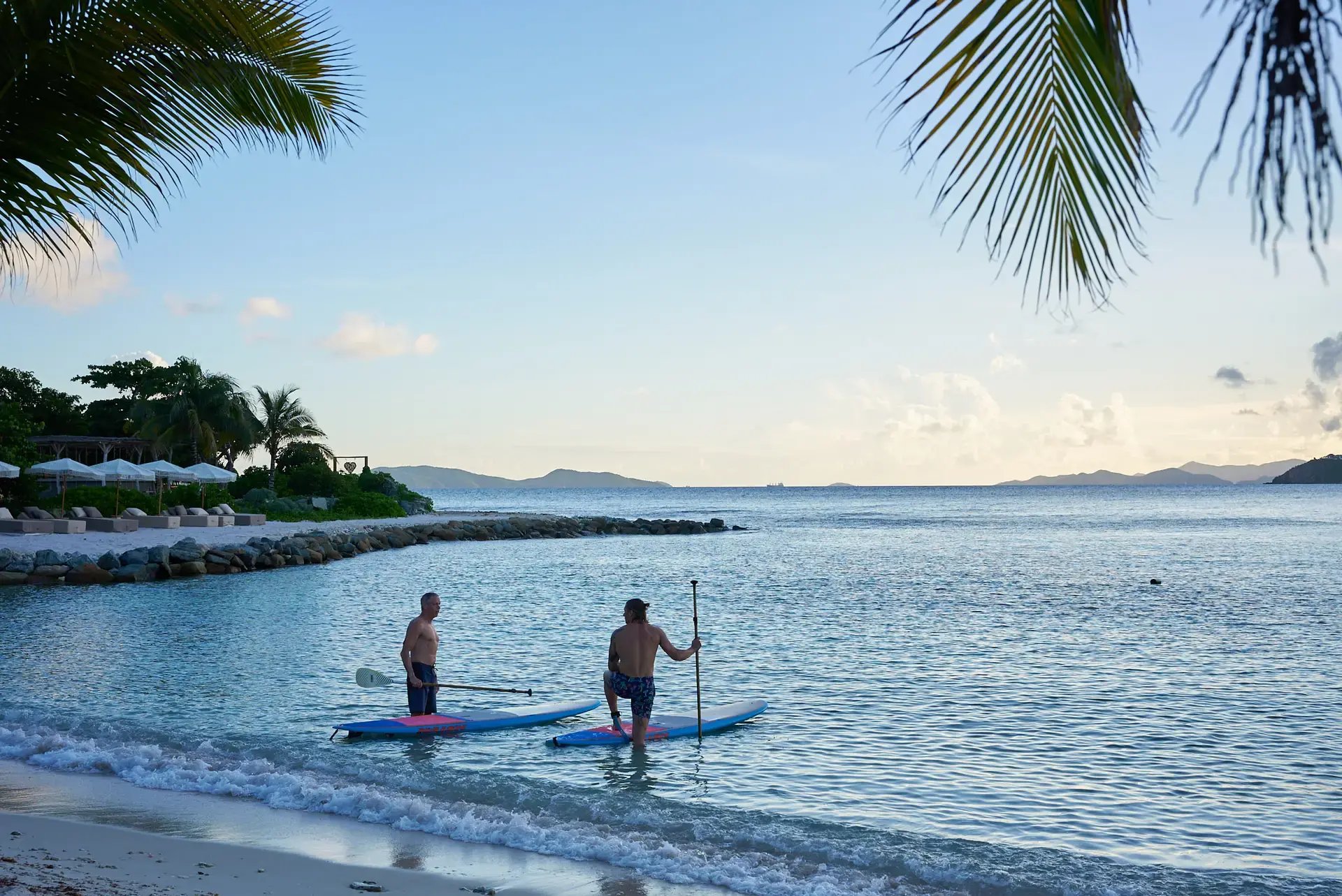 Guests stand-up paddleboarding near the shore at The Aerial, BVI.