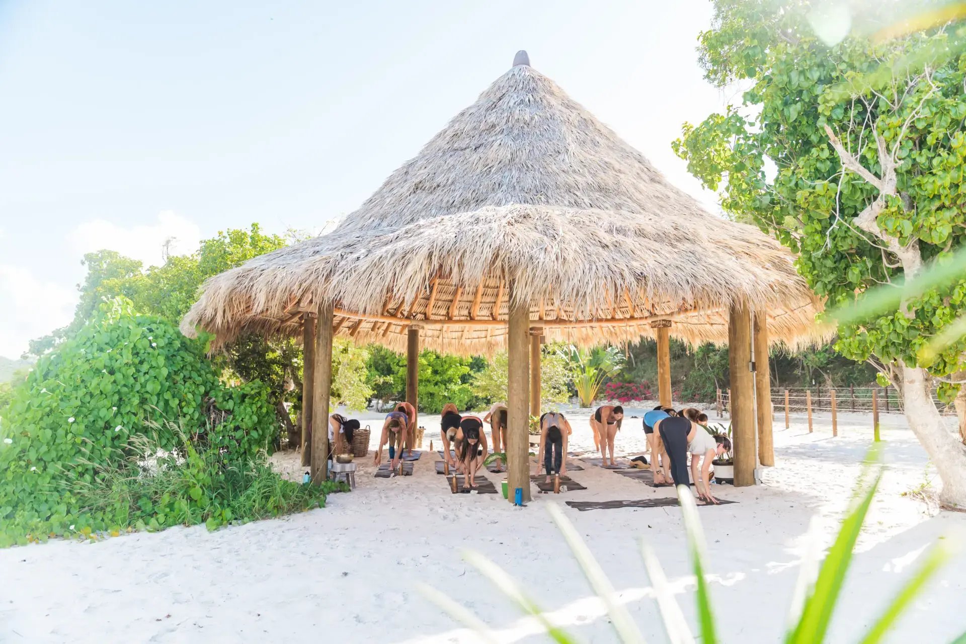 Group yoga session under a beach pavilion at The Aerial, BVI
