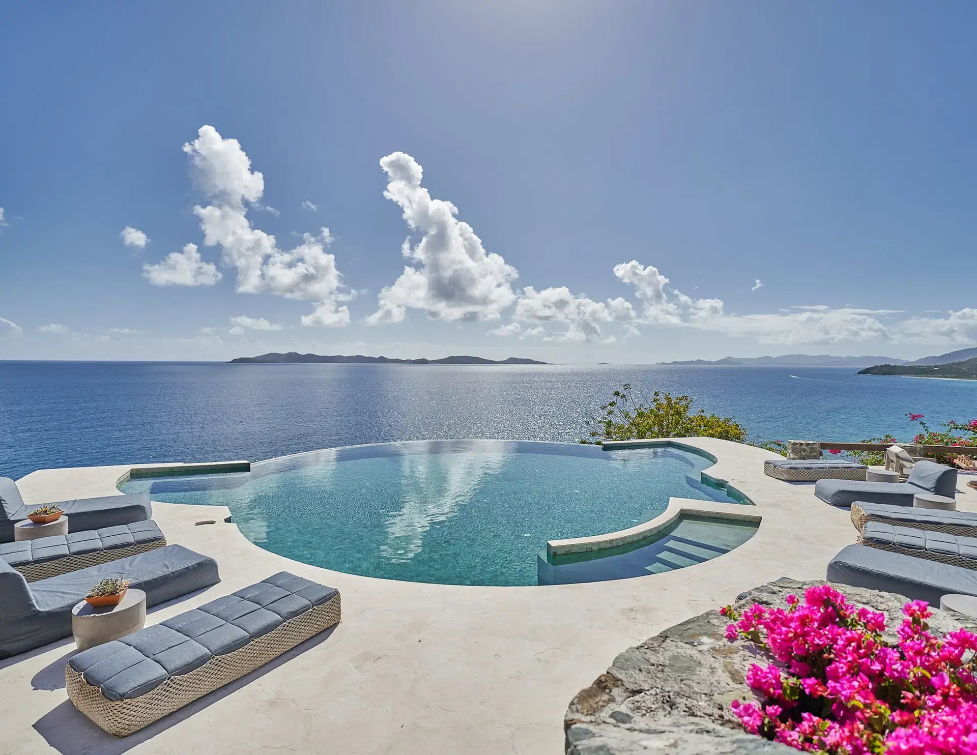 Infinity pool overlooking the ocean with lounge chairs at The Aerial, BVI.