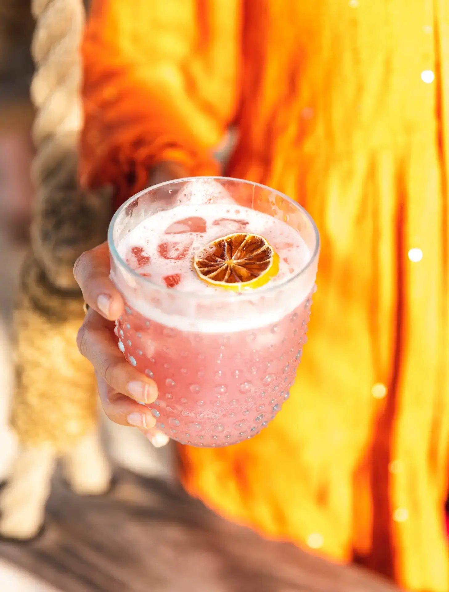 Guest holding a garnished pink cocktail at The Aerial BVI