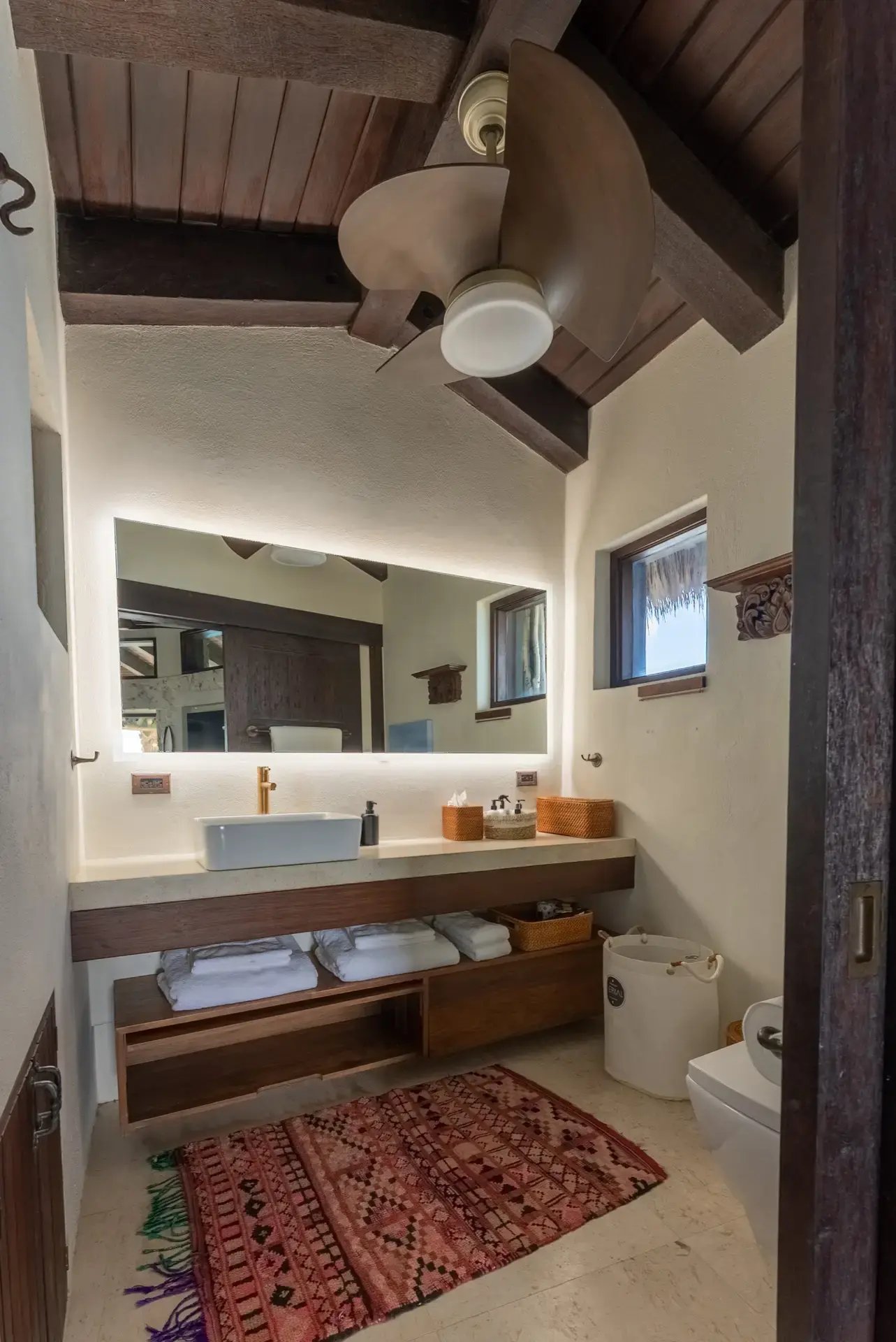 Bathroom vanity with backlit mirror and open shelving at The Aerial, BVI