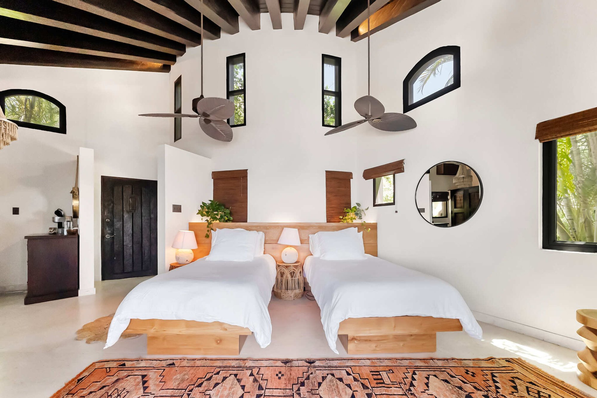 Twin beds in a domed room with round mirror and skylights.