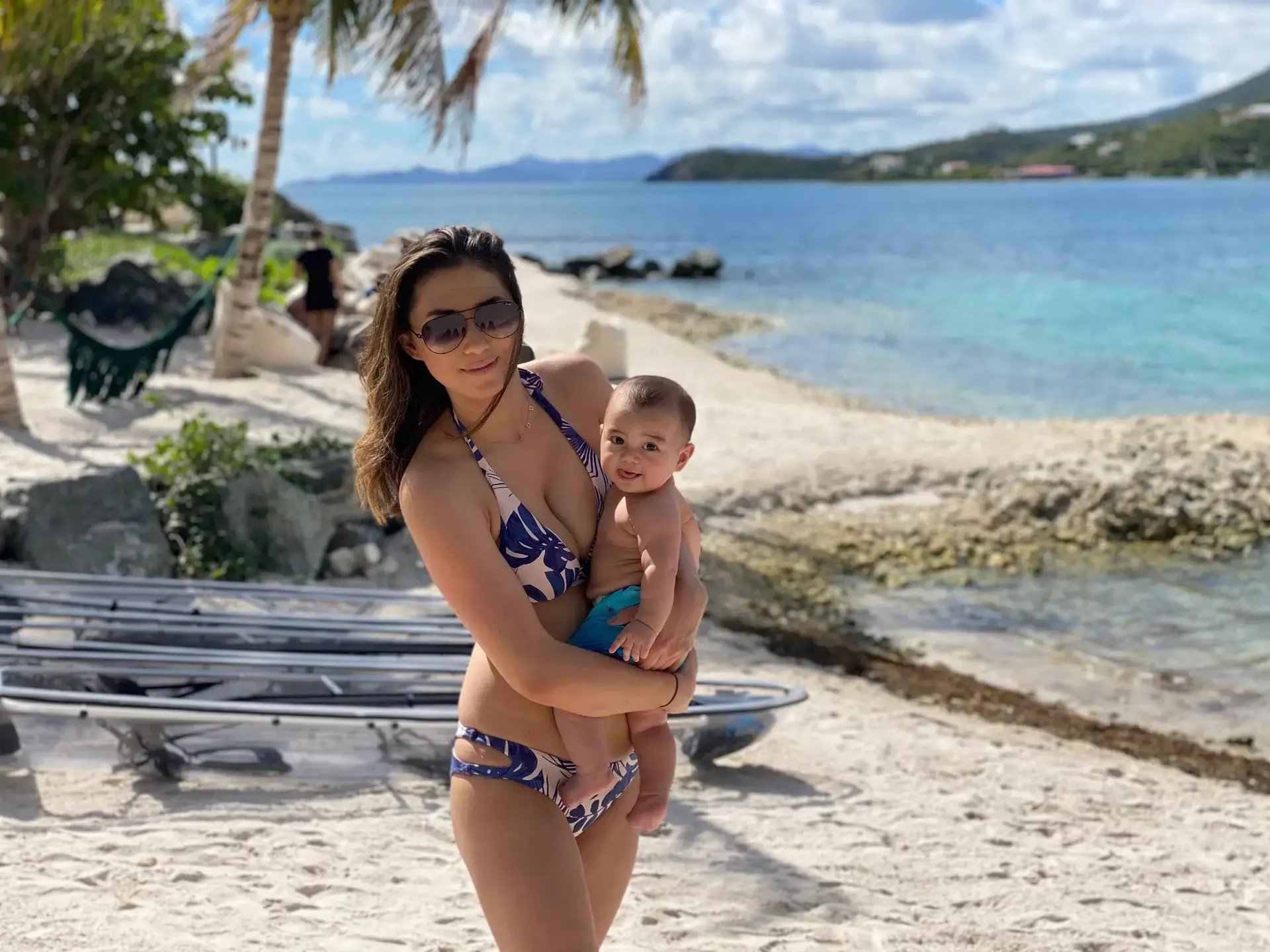 Mother holding her toddler on the beach at The Aerial BVI