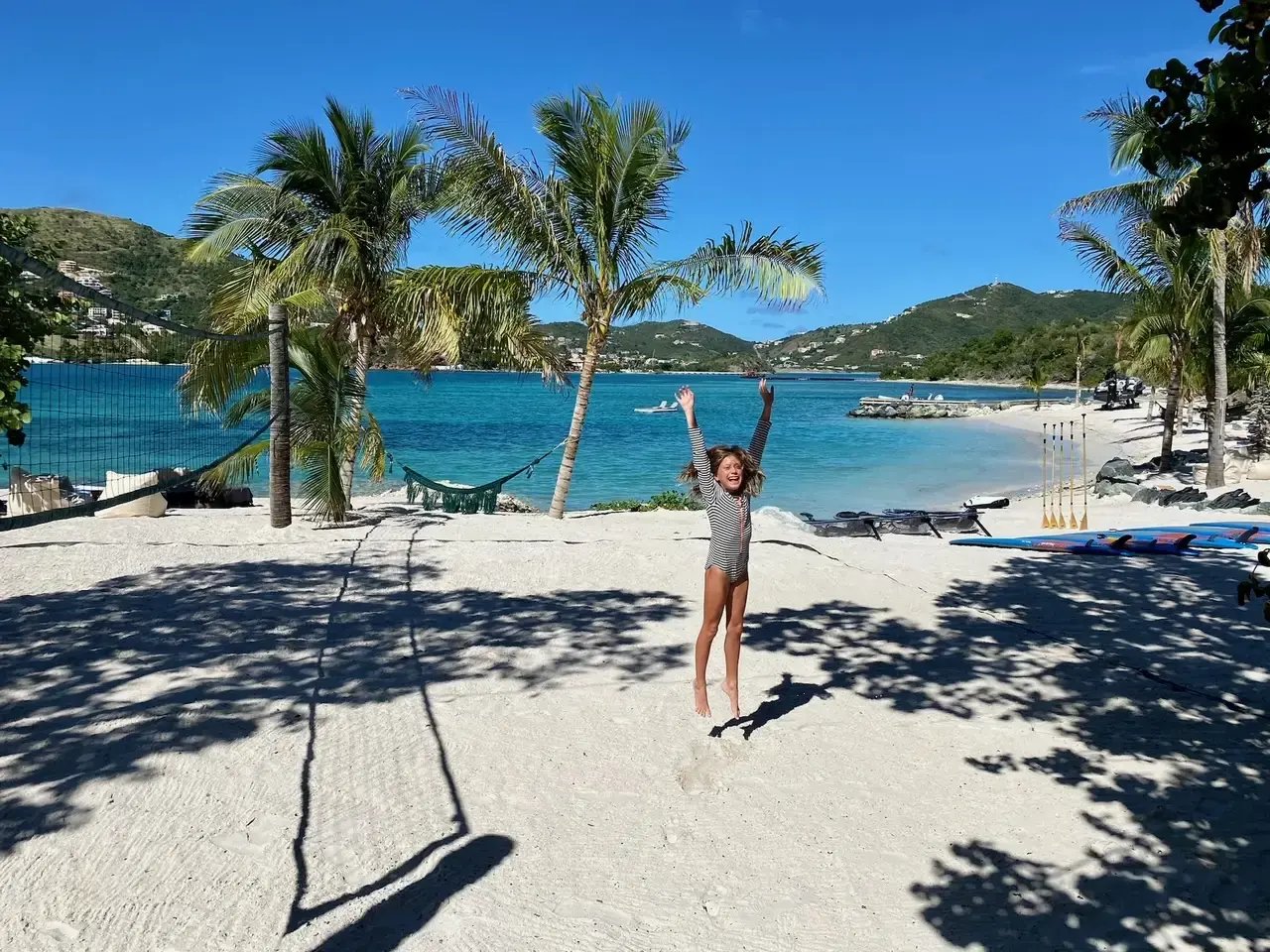 Child playing volleyball on the beach court at The Aerial BVI