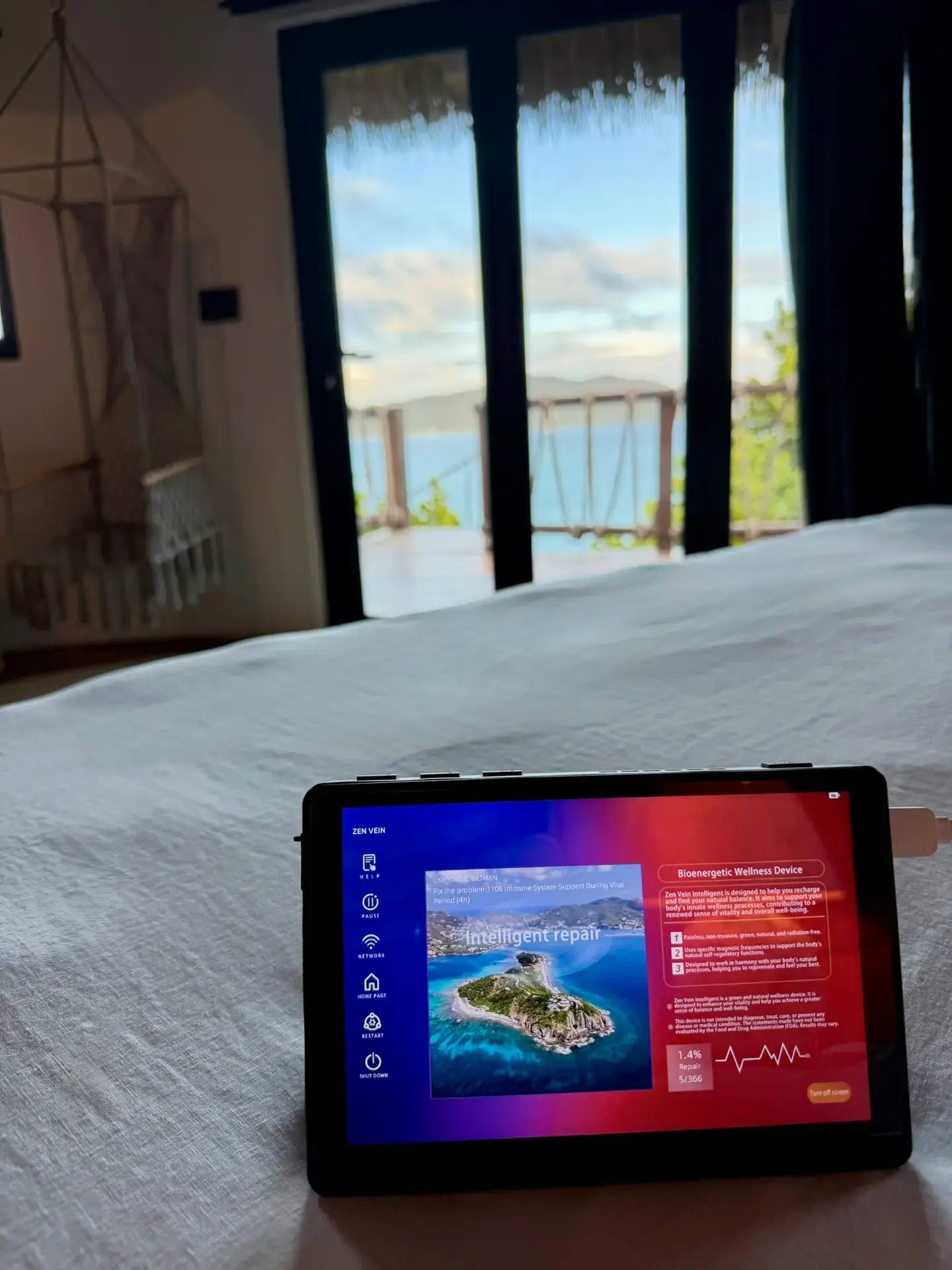 Zen Vein tablet display on a bed with an ocean view in the background.