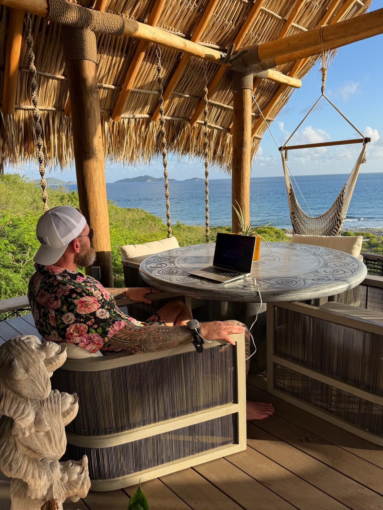 Man working on laptop in an ocean-view cabana at The Aerial, BVI.
