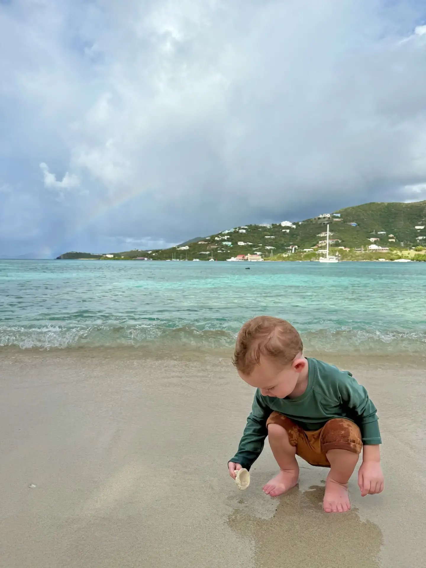 Toddler playing on the beach shoreline at The Aerial BVI