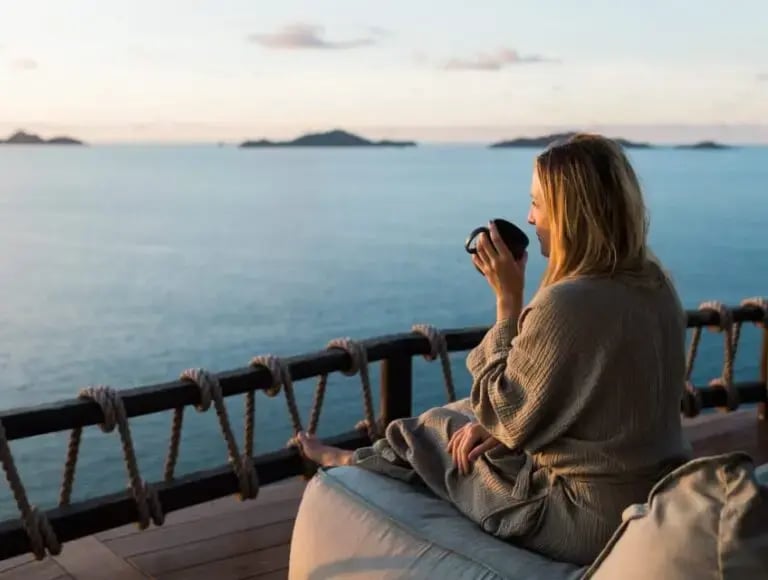 Guest sitting on an ocean-view deck at The Aerial, BVI