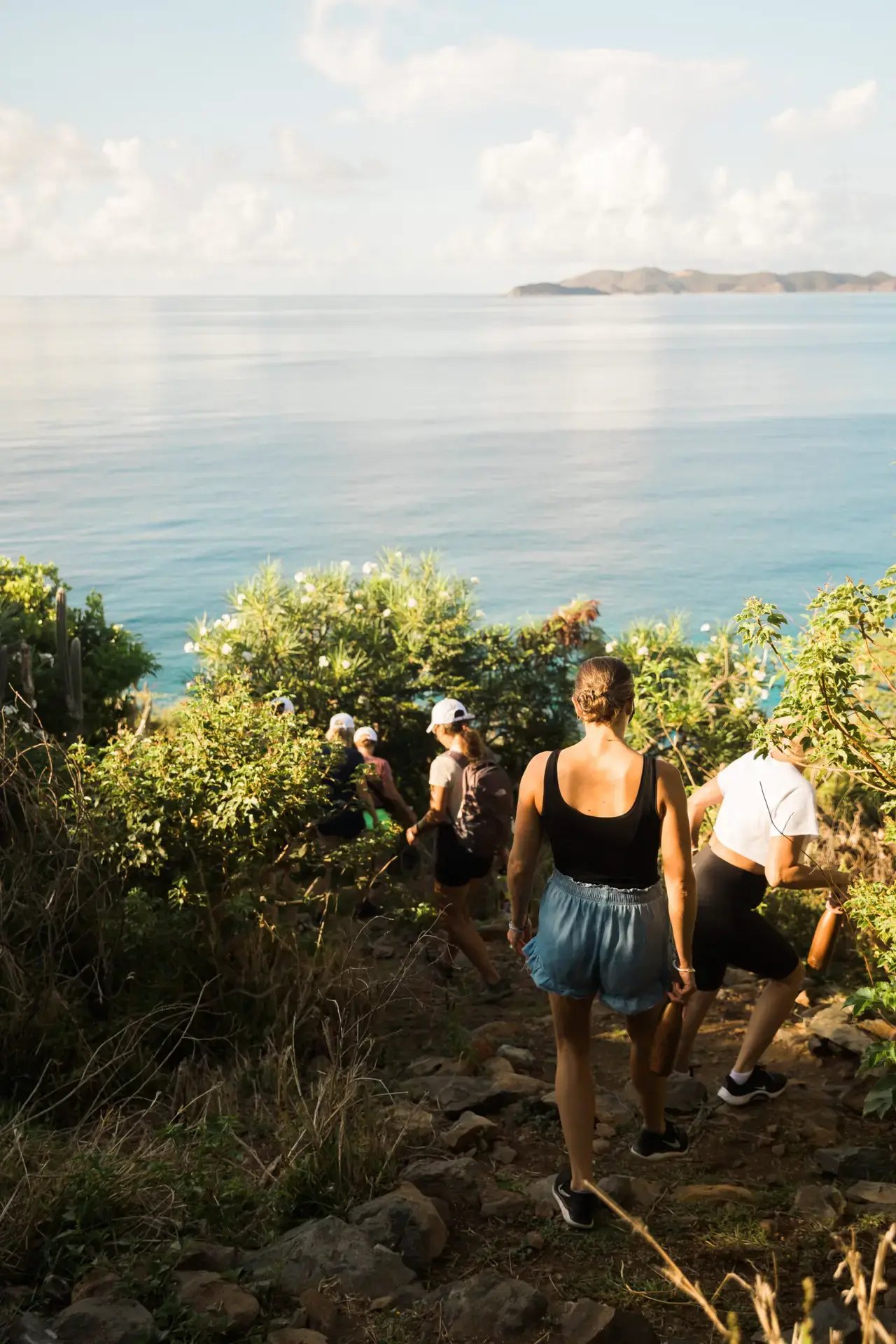 Two people hiking a coastal trail overlooking the ocean
