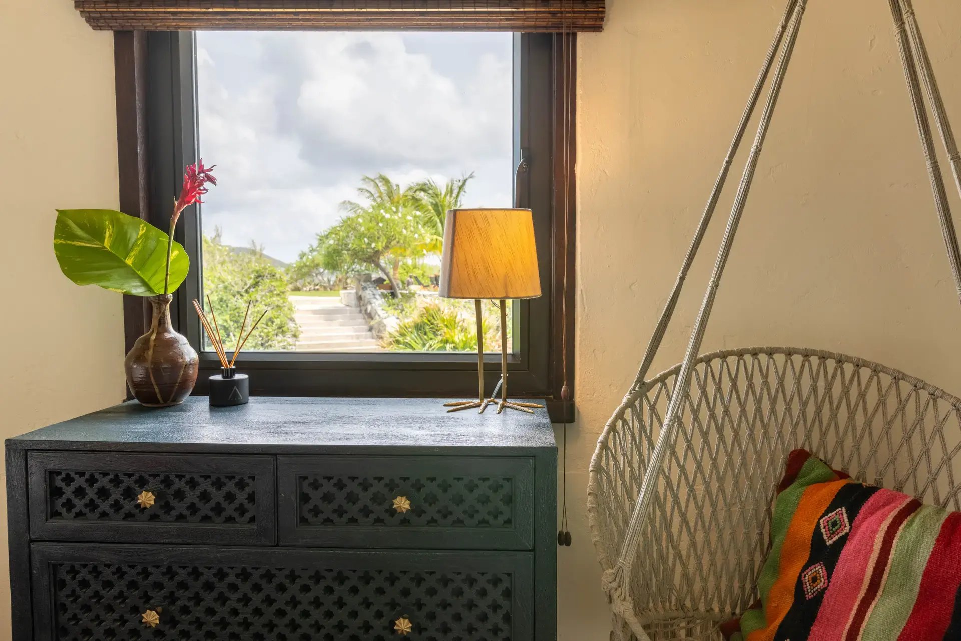 Nightstand with lamp and hanging chair by the window at The Aerial, BVI