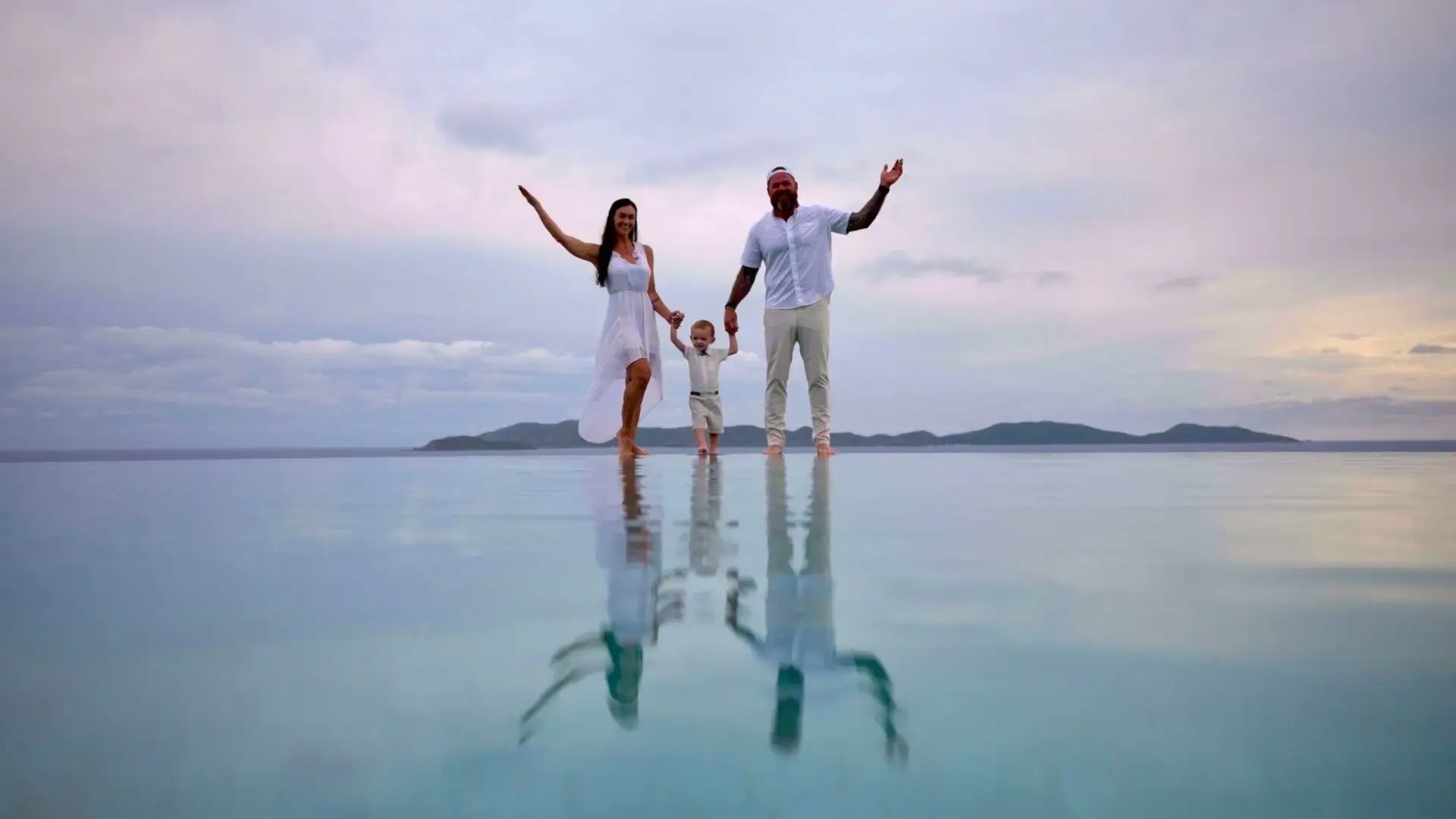 Family celebrating together in shallow reflective water at The Aerial, BVI