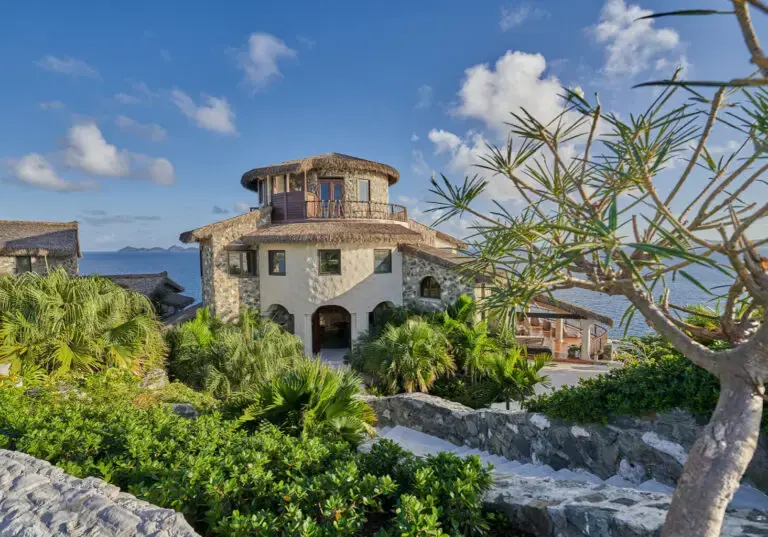 Stone villa surrounded by greenery overlooking the ocean