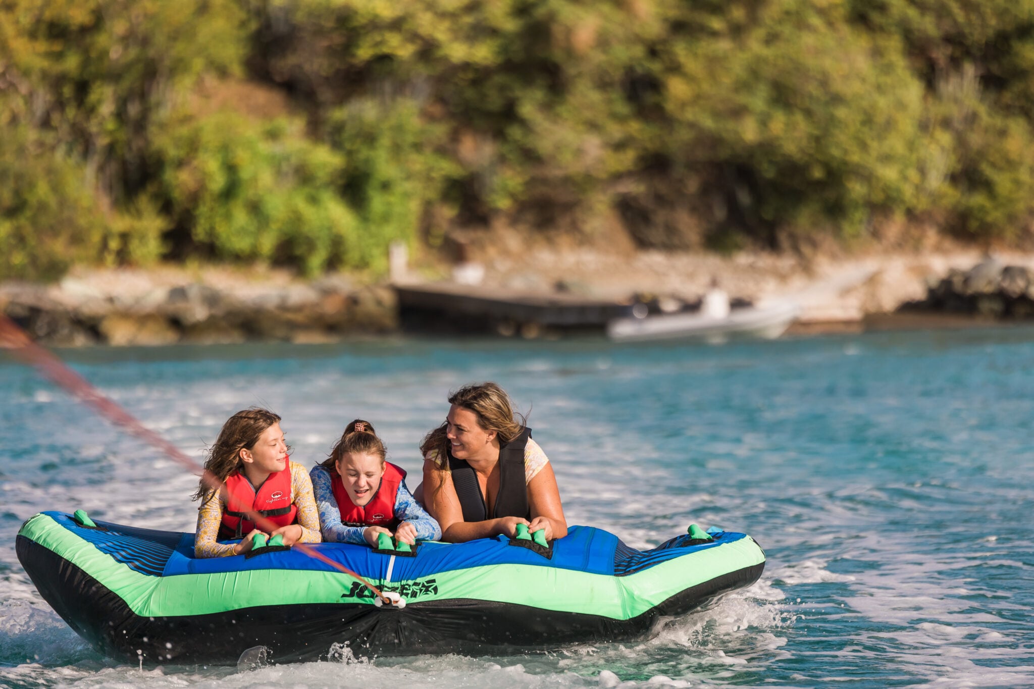 Guests riding an inflatable tube on the water at The Aerial, BVI