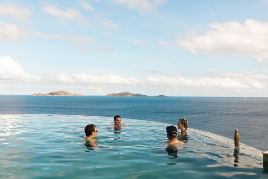 group of vacationers enjoy the best time to visit BVI in infinity pool